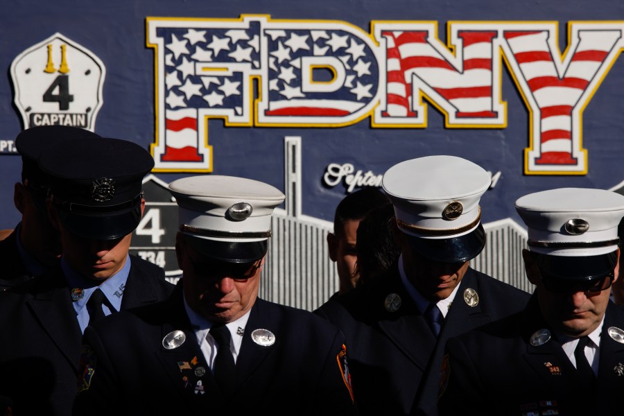 New York City firefighters bow their heads during a moment of silence outside Engine 4 Ladder 15 on the 23rd anniversary of the Sept. 11, 2001 attacks, Wednesday, Sept. 11, 2024, in New York. (AP Photo/Stefan Jeremiah)