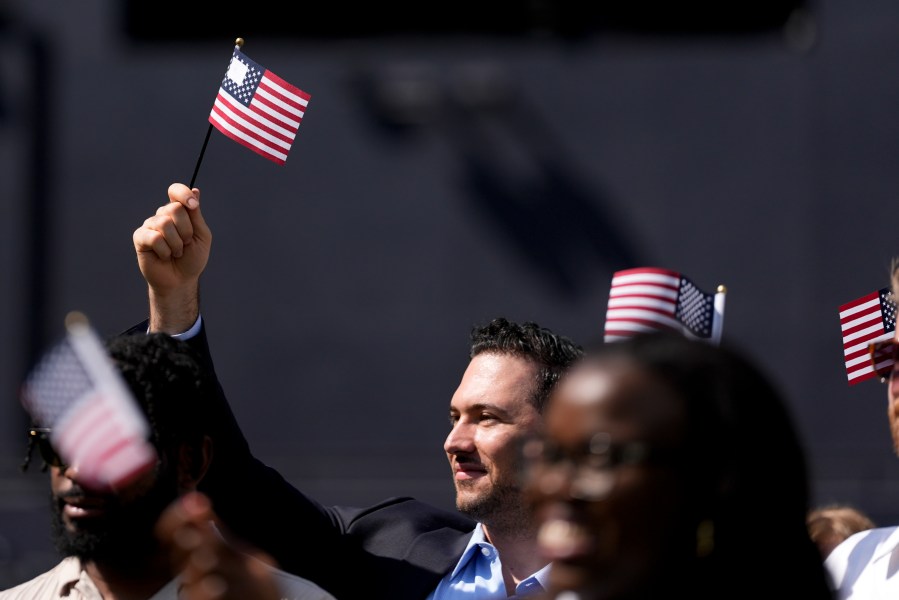 A man, part of a group of 50 new United States citizens from 25 different countries, takes part in a naturalization ceremony before the San Diego Padres host the Minnesota Twins in a baseball game at Petco Park, Wednesday, Aug. 21, 2024, in San Diego. (AP Photo/Gregory Bull)