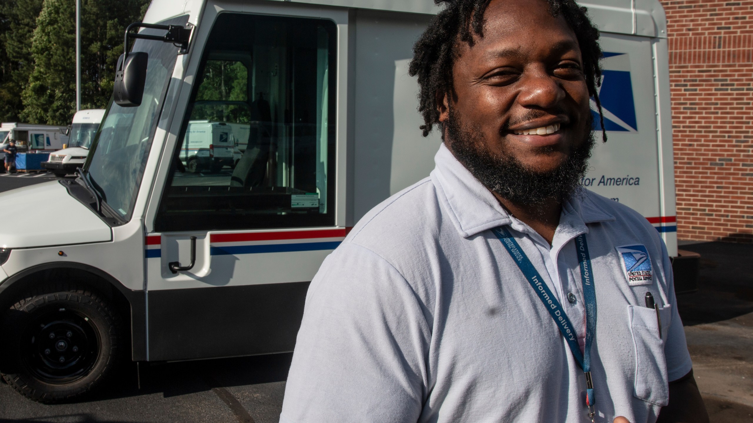 U.S. Postal Service delivery driver Richard Burton stands in the work lot of a postal facility in Athens, Ga., Thursday, Sept. 5, 2024. (AP Photo/Ron Harris)