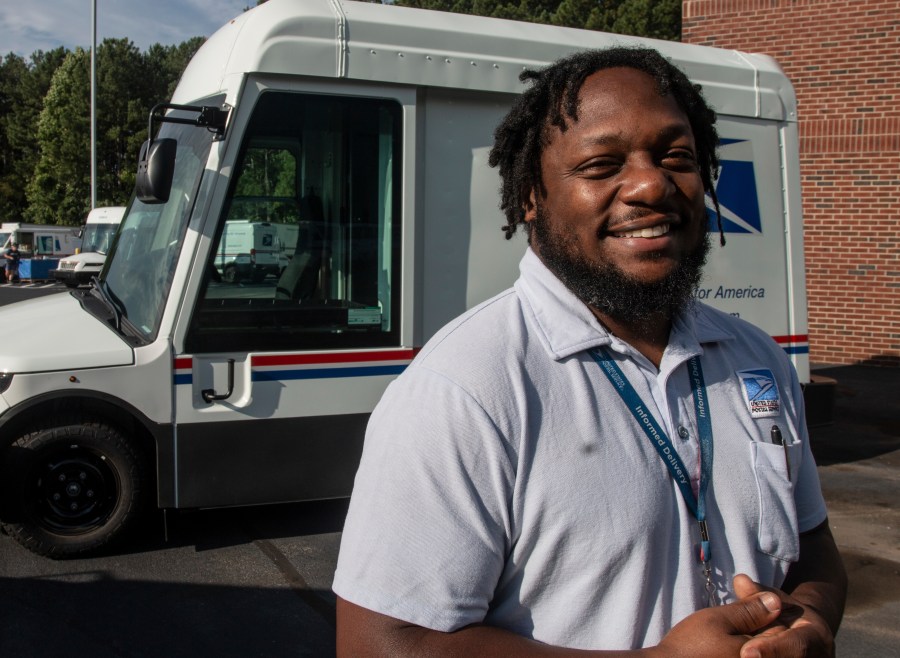 U.S. Postal Service delivery driver Richard Burton stands in the work lot of a postal facility in Athens, Ga., Thursday, Sept. 5, 2024. (AP Photo/Ron Harris)