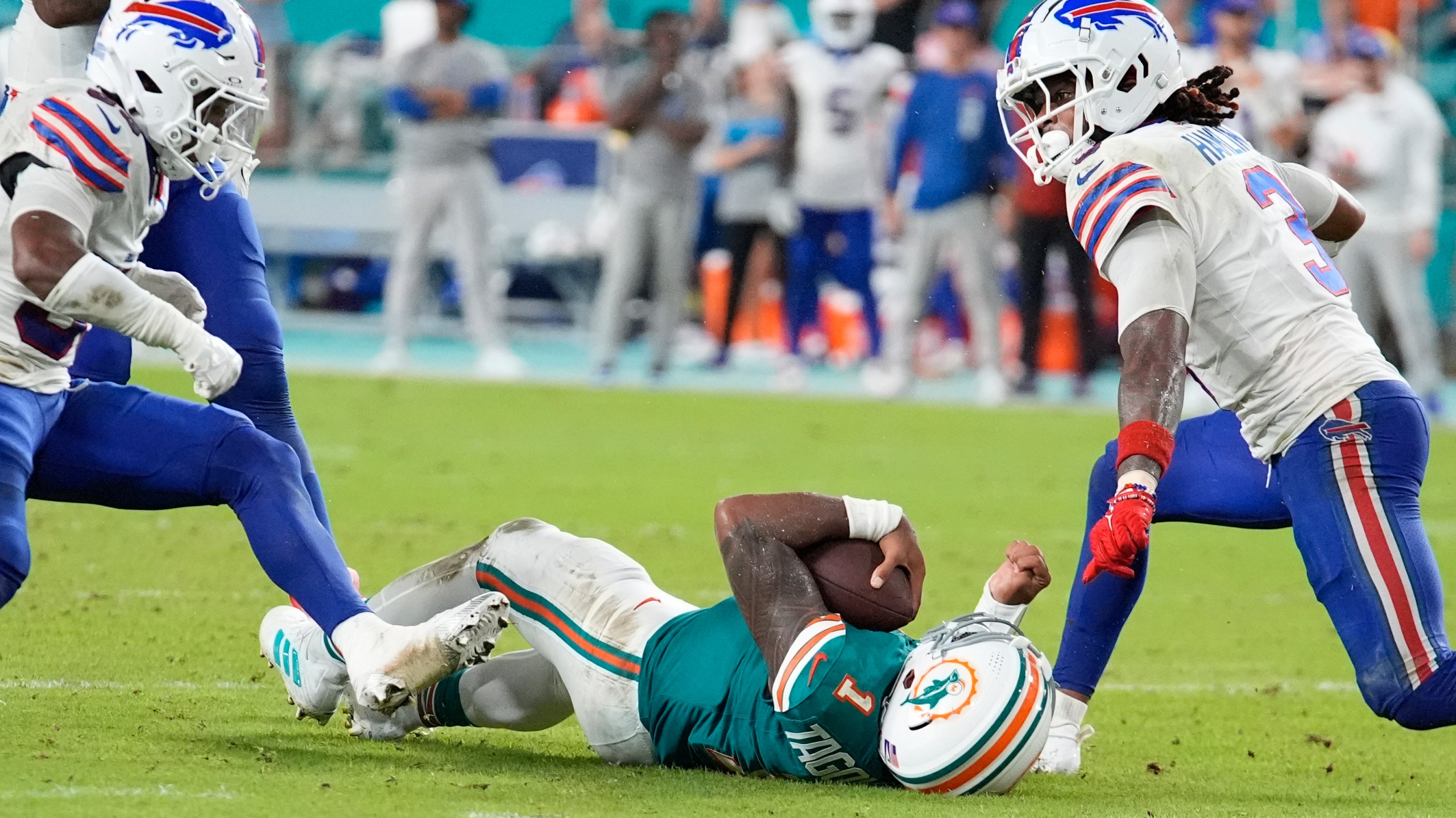 Miami Dolphins quarterback Tua Tagovailoa (1) falls in the field after colliding with Buffalo Bills safety Damar Hamlin (3) during the second half of an NFL football game, Thursday, Sept. 12, 2024, in Miami Gardens, Fla. (AP Photo/Rebecca Blackwell)