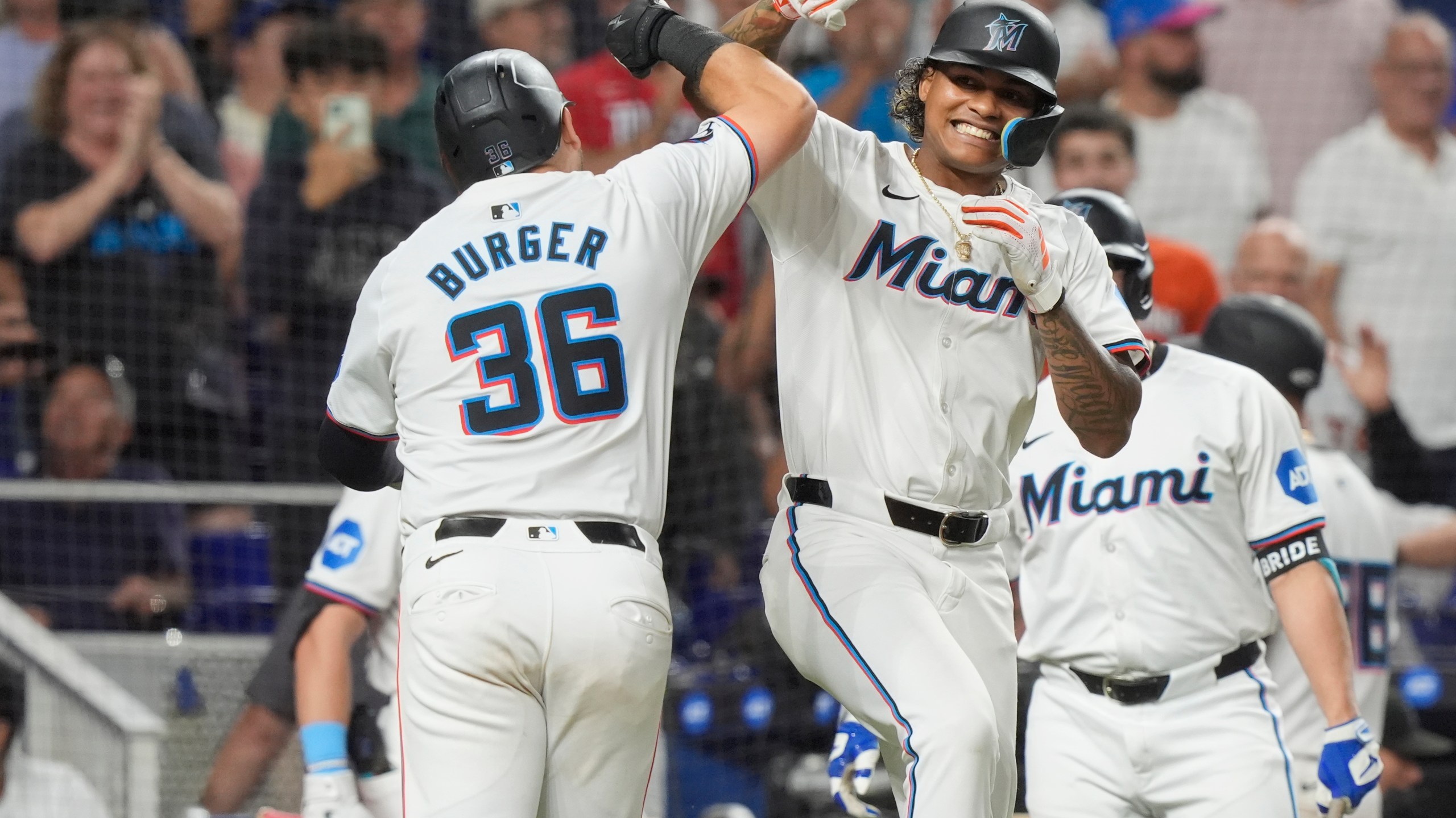 Miami Marlins' Cristian Pache and Jake Burger (36) celebrate Burger's two-run home run doing the eighth inning of a baseball game against the Los Angeles Dodgers, Tuesday, Sept. 17, 2024, in Miami. (AP Photo/Marta Lavandier)