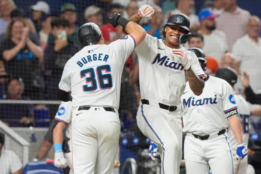 Miami Marlins' Cristian Pache and Jake Burger (36) celebrate Burger's two-run home run doing the eighth inning of a baseball game against the Los Angeles Dodgers, Tuesday, Sept. 17, 2024, in Miami. (AP Photo/Marta Lavandier)