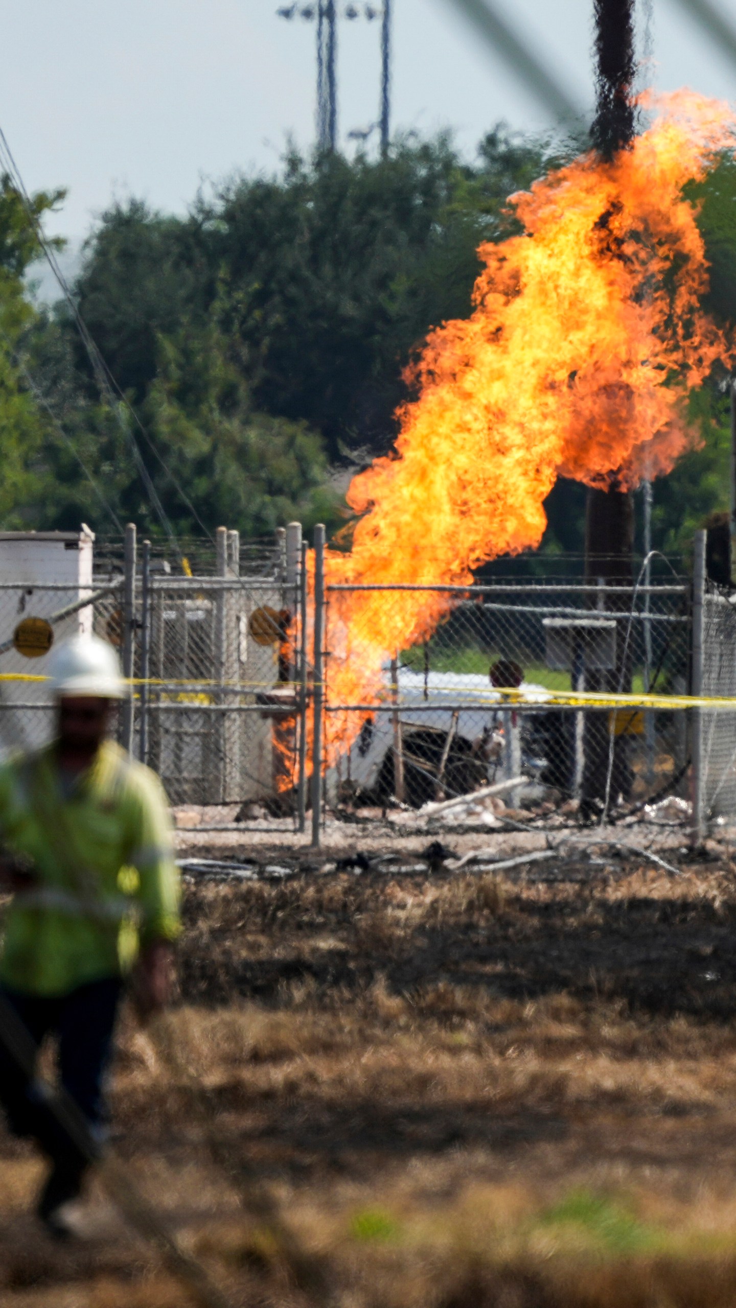 An above-ground valve continues to burn three days after after a vehicle drove through a fence along a parking lot and struck the site, Wednesday, Sept. 18, 2024, in La Porte, Texas. (Jason Fochtman/Houston Chronicle via AP)