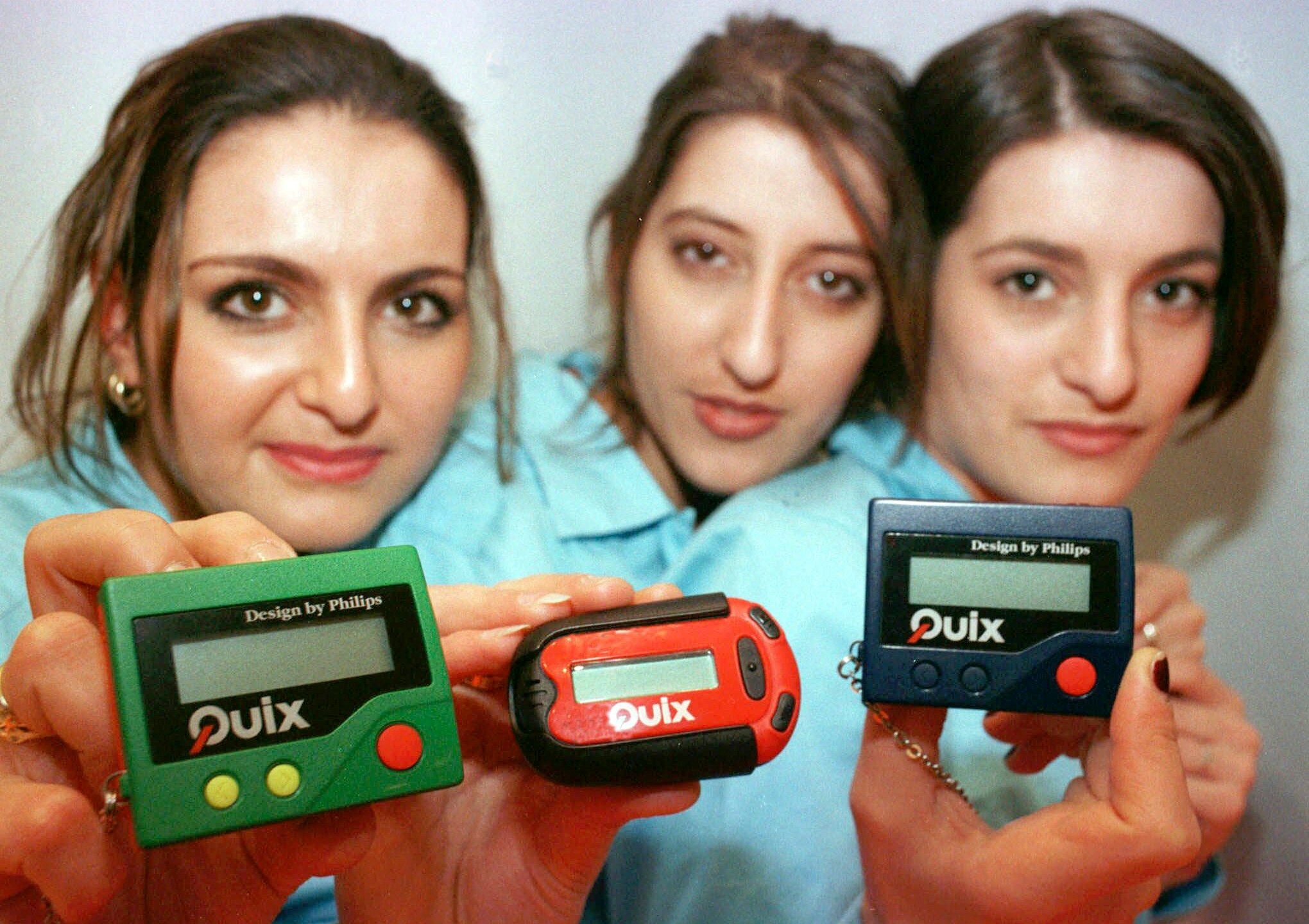 FILE - Three women hold the pager 'Quix' as they present it at CeBIT '97 in Hannover, Germany, Tuesday March 18, 1997. The beep-beep-beep of a small black box on your belt or in your pocket was something of a status symbol decades before the smartphone wiped it from popular culture. (AP Photo/Fabian Bimmer, File)