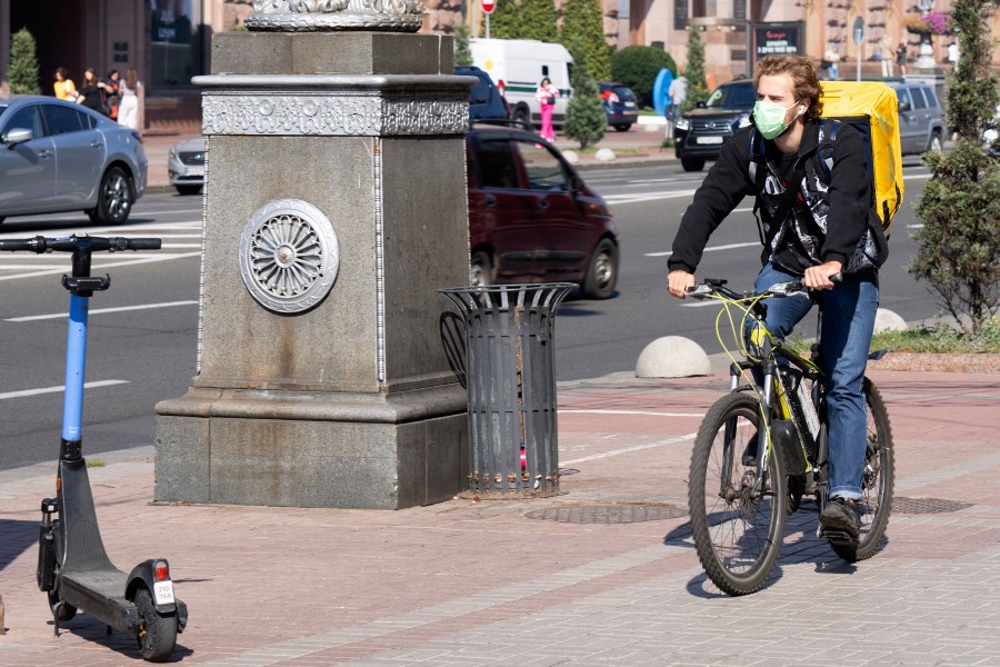 A delivery cyclist wearing a face mask cycles down a street in Kyiv, Ukraine, Friday Sept. 20, 2024 on a day with poor air quality. (AP Photo/Tony Hicks)