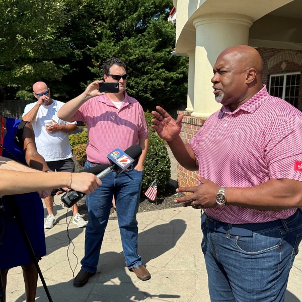 North Carolina Republican gubernatorial candidate Mark Robinson, right, speaks with reporters outside the Olympic Family Restaurant in Colfax, N.C., where Robinson held a campaign event on Monday, Aug. 26, 2024. (AP Photo/Gary D. Robertson)