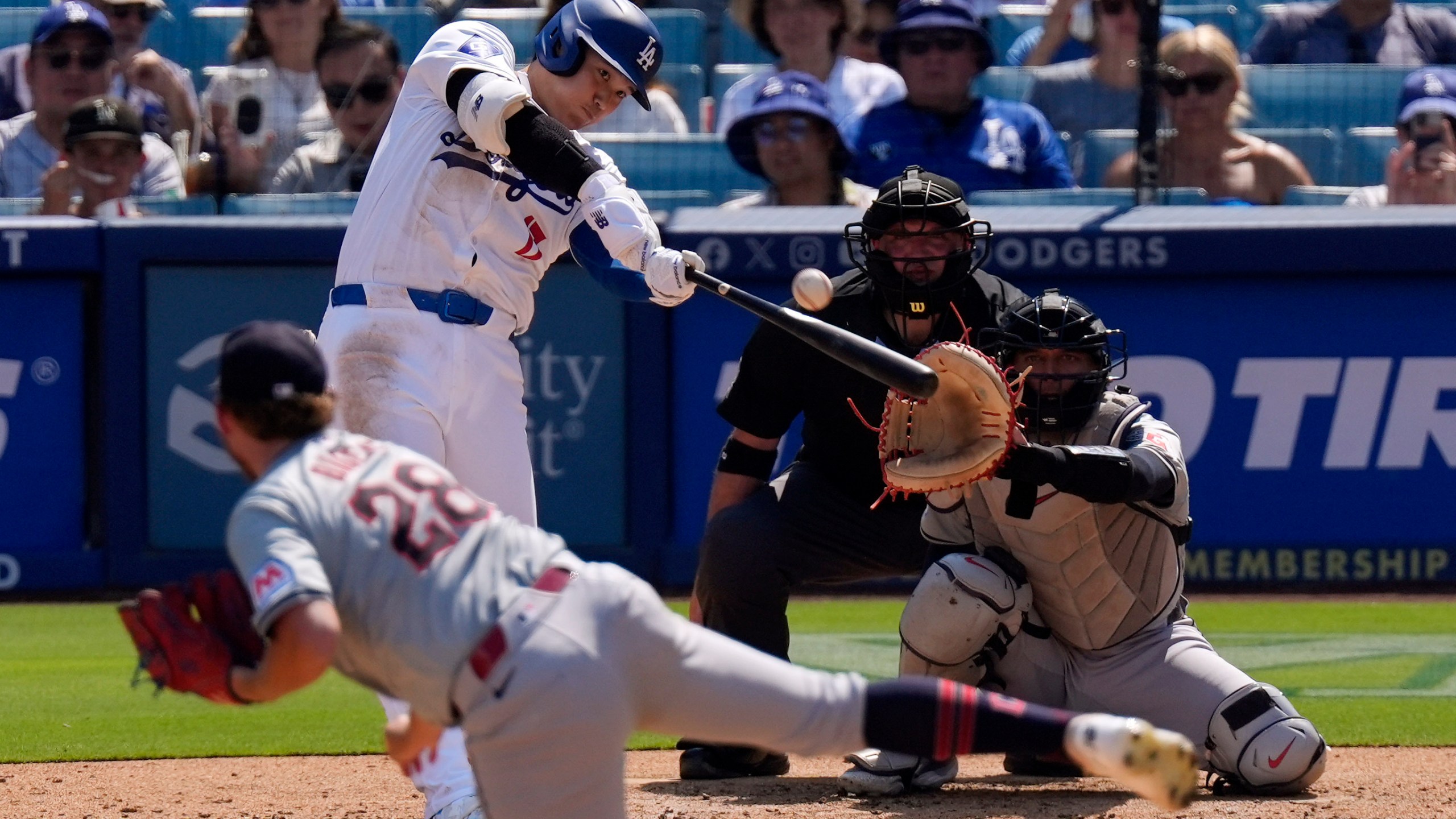 Los Angeles Dodgers' Shohei Ohtani, second from left, hits a solo home run as Cleveland Guardians starting pitcher Tanner Bibee, left, watches along with catcher Bo Naylor, right, and home plate umpire Dan Bellino during the fifth inning of a baseball game, Sunday, Sept. 8, 2024, in Los Angeles. (AP Photo/Mark J. Terrill)