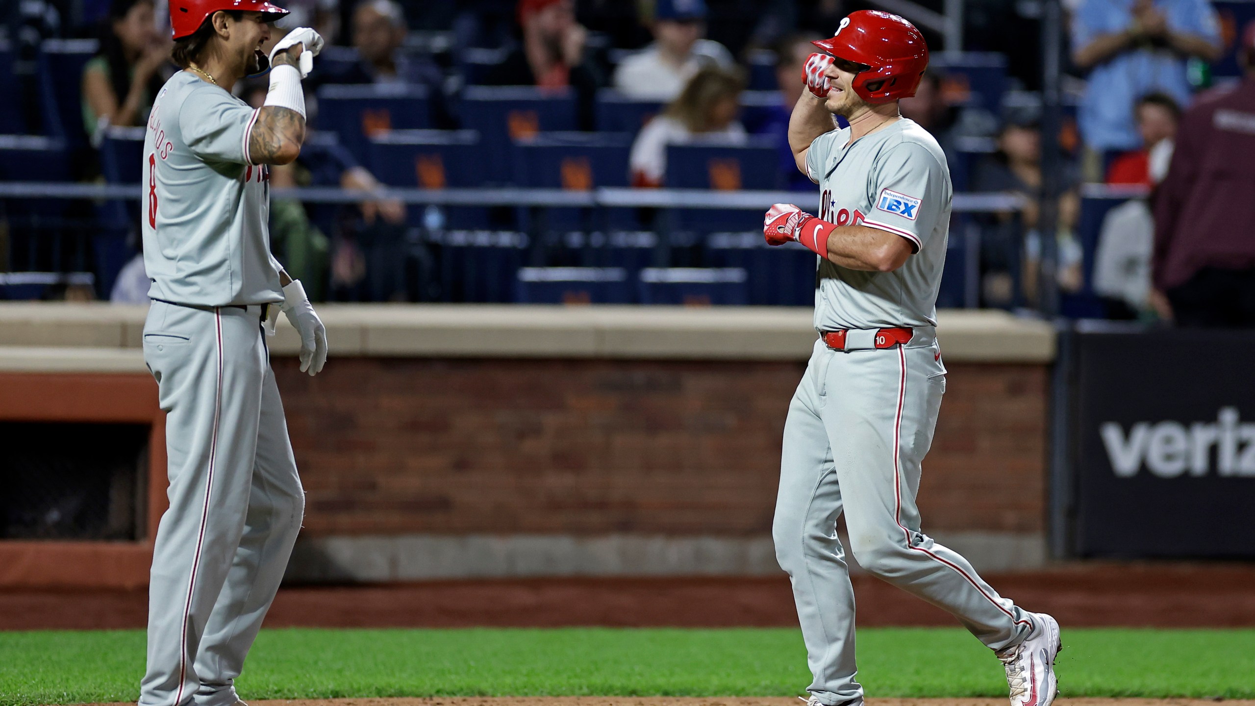 Philadelphia Phillies' J.T. Realmuto, right, is congratulated by Nick Castellanos, left, after hitting a two-run home run during the eighth inning of a baseball game against the New York Mets, Friday, Sept. 20, 2024, in New York. (AP Photo/Adam Hunger)