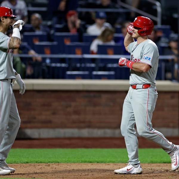 Philadelphia Phillies' J.T. Realmuto, right, is congratulated by Nick Castellanos, left, after hitting a two-run home run during the eighth inning of a baseball game against the New York Mets, Friday, Sept. 20, 2024, in New York. (AP Photo/Adam Hunger)