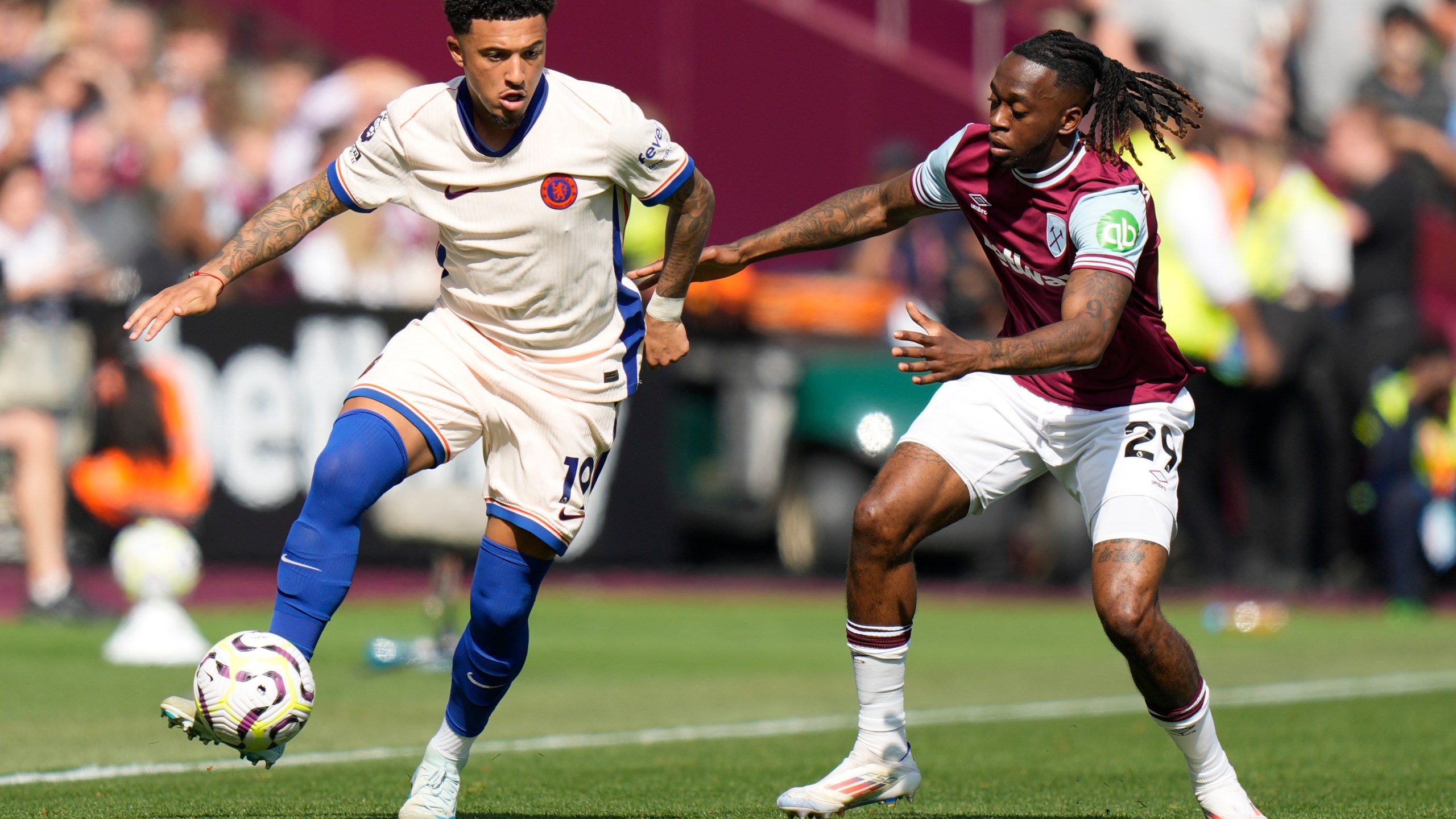 Chelsea's Jadon Sancho, left, and West Ham's Aaron Wan-Bissaka fight for the ball during the English Premier League soccer match between West Ham United and Chelsea at the London stadium in London, Saturday, Sept. 21, 2024. (AP Photo/Alastair Grant)