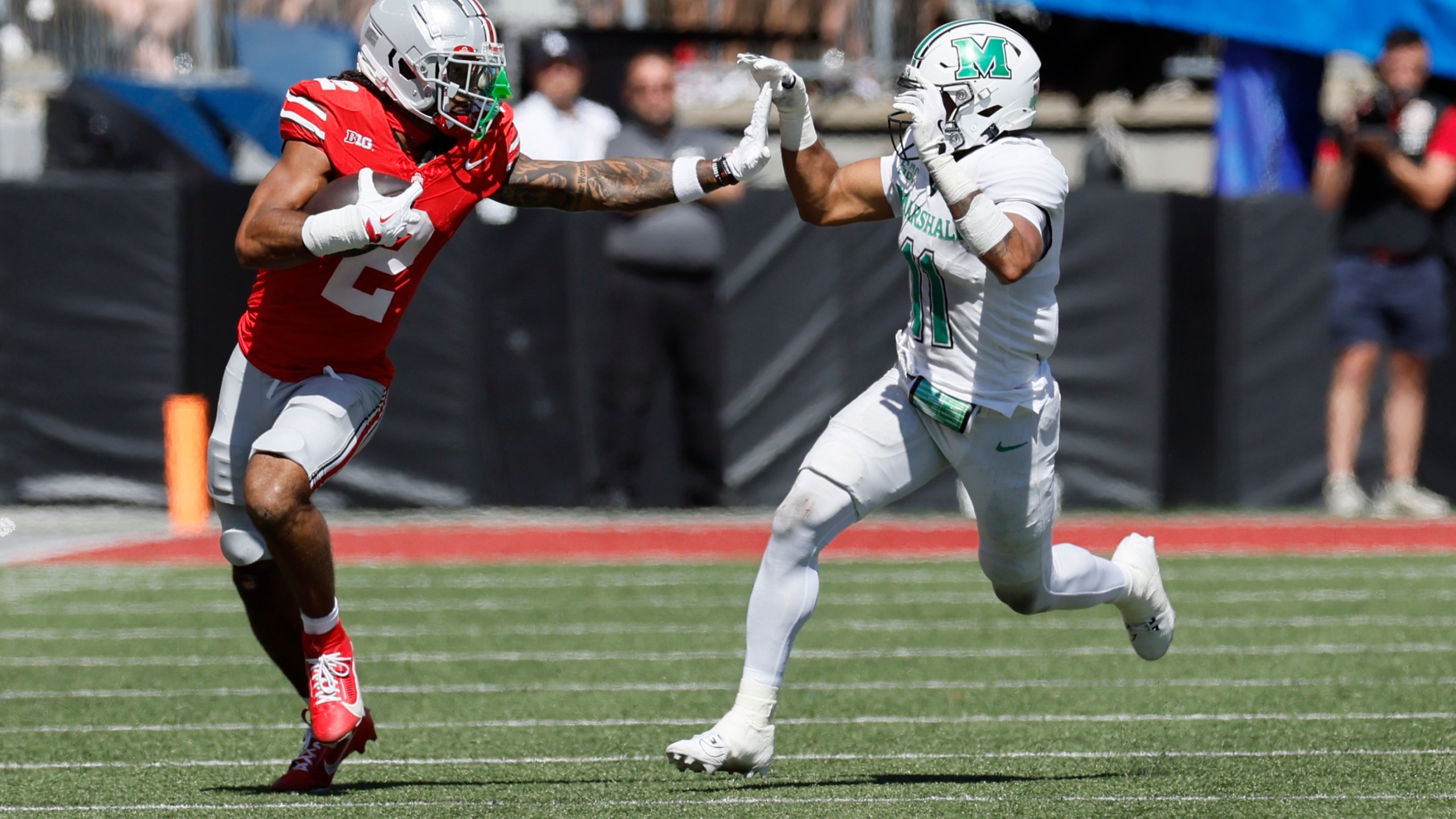 Ohio State receiver Emeka Egbuka, left, tries to stiff arm Marshall defensive back J.J. Roberts during the first half of an NCAA college football game Saturday, Sept. 21, 2024, in Columbus, Ohio. (AP Photo/Jay LaPrete)