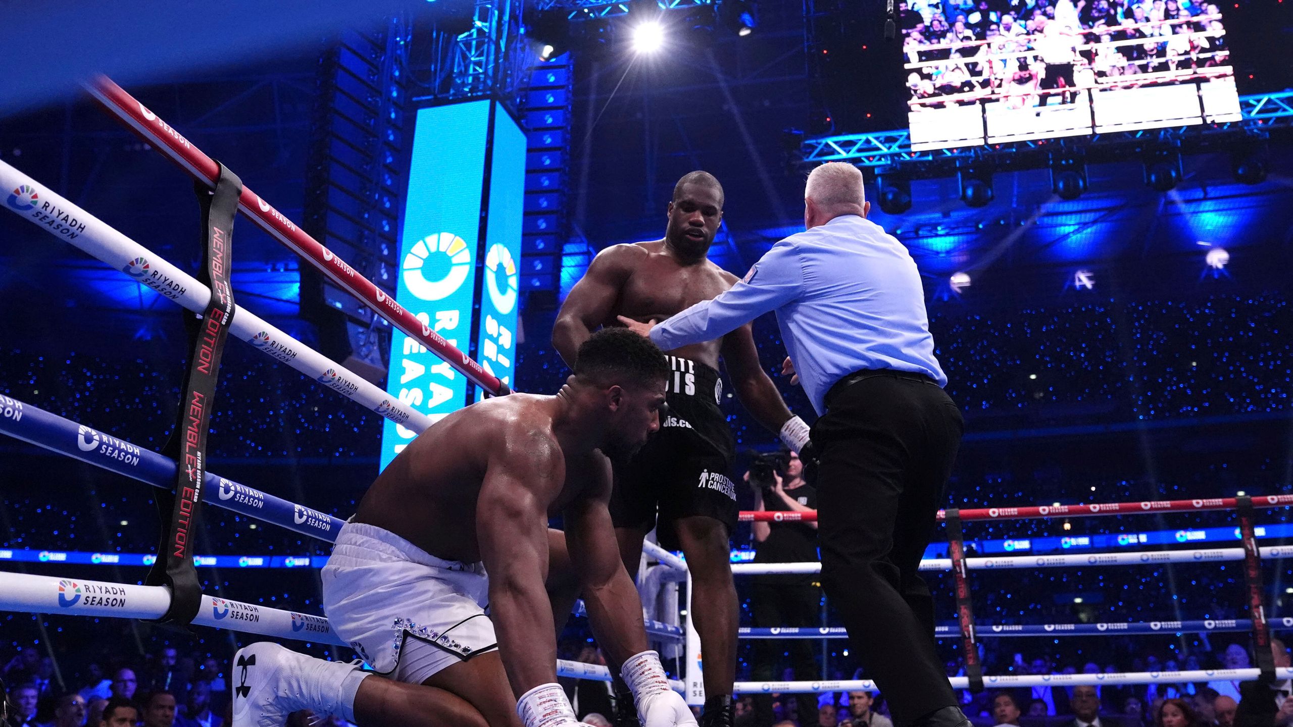 Daniel Dubois, centre, knocks down Anthony Joshua in the IBF World Heavyweight bout at Wembley Stadium, in London, Saturday, Sept. 21, 2024. (Bradley Collyer/PA via AP)