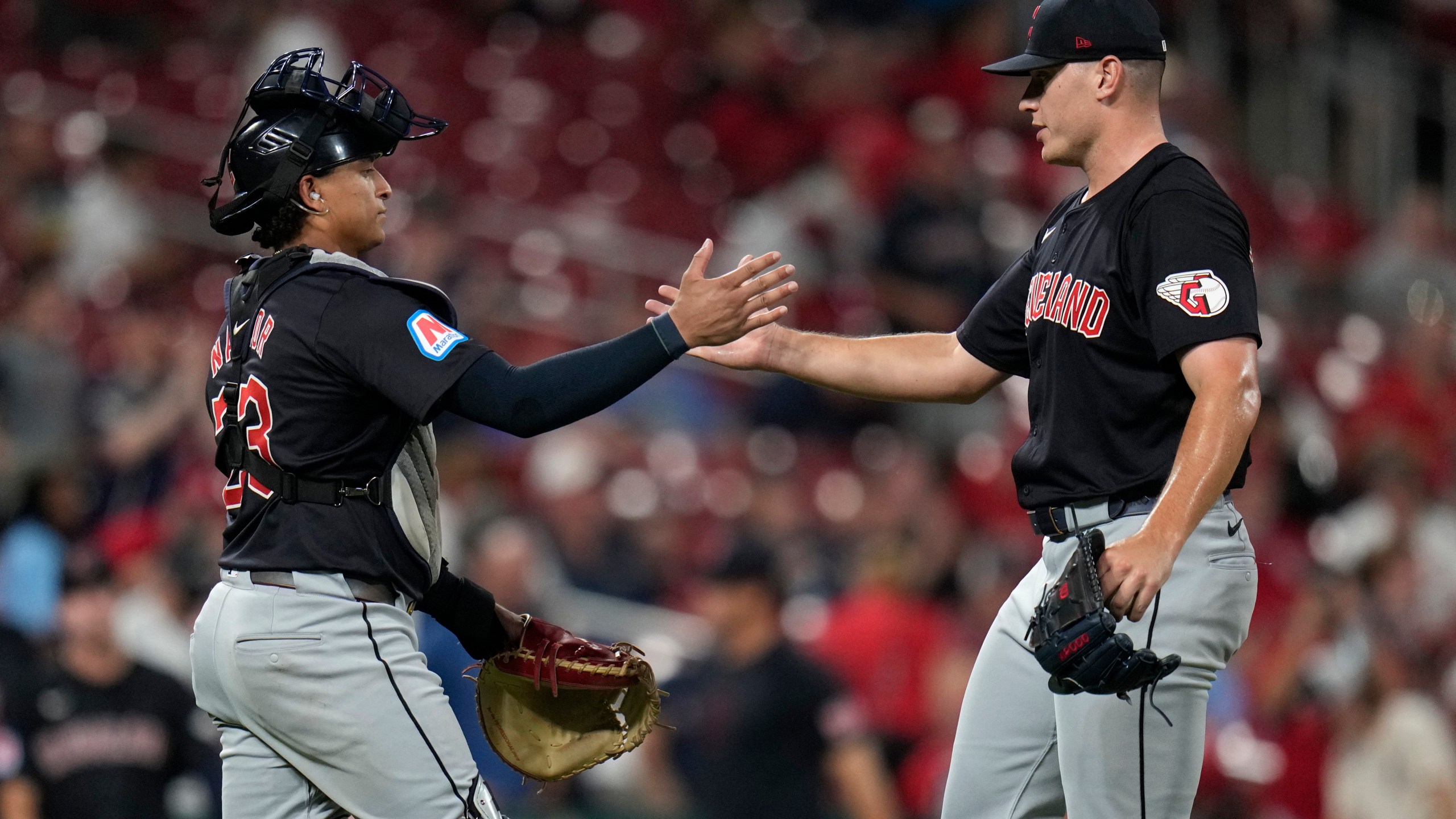 Cleveland Guardians relief pitcher Erik Sabrowski, right, and catcher Bo Naylor celebrate a 5-1 victory over the St. Louis Cardinals in a baseball game Friday, Sept. 20, 2024, in St. Louis. (AP Photo/Jeff Roberson)