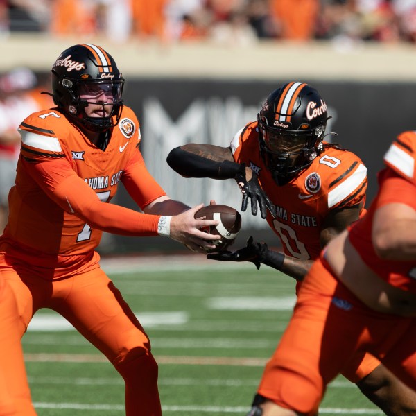 Oklahoma State quarterback Alan Bowman (7) hands the ball off to running back Ollie Gordon II (0) in the first half of an NCAA college football game against Utah Saturday, Sept. 21, 2024, in Stillwater, Okla. (AP Photo/Mitch Alcala)