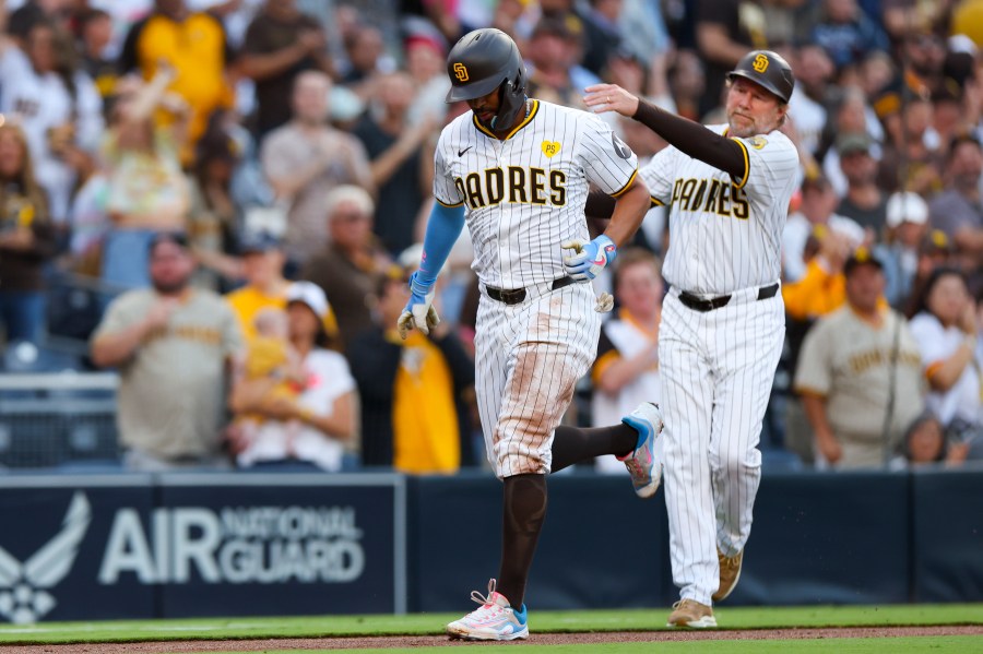 San Diego Padres' Xander Bogaerts, left, celebrates a two-run home run with third base coach Tim Leiper during the second inning of a baseball game against the Chicago White Sox, Saturday, Sept. 21, 2024, in San Diego. (AP Photo/Ryan Sun)