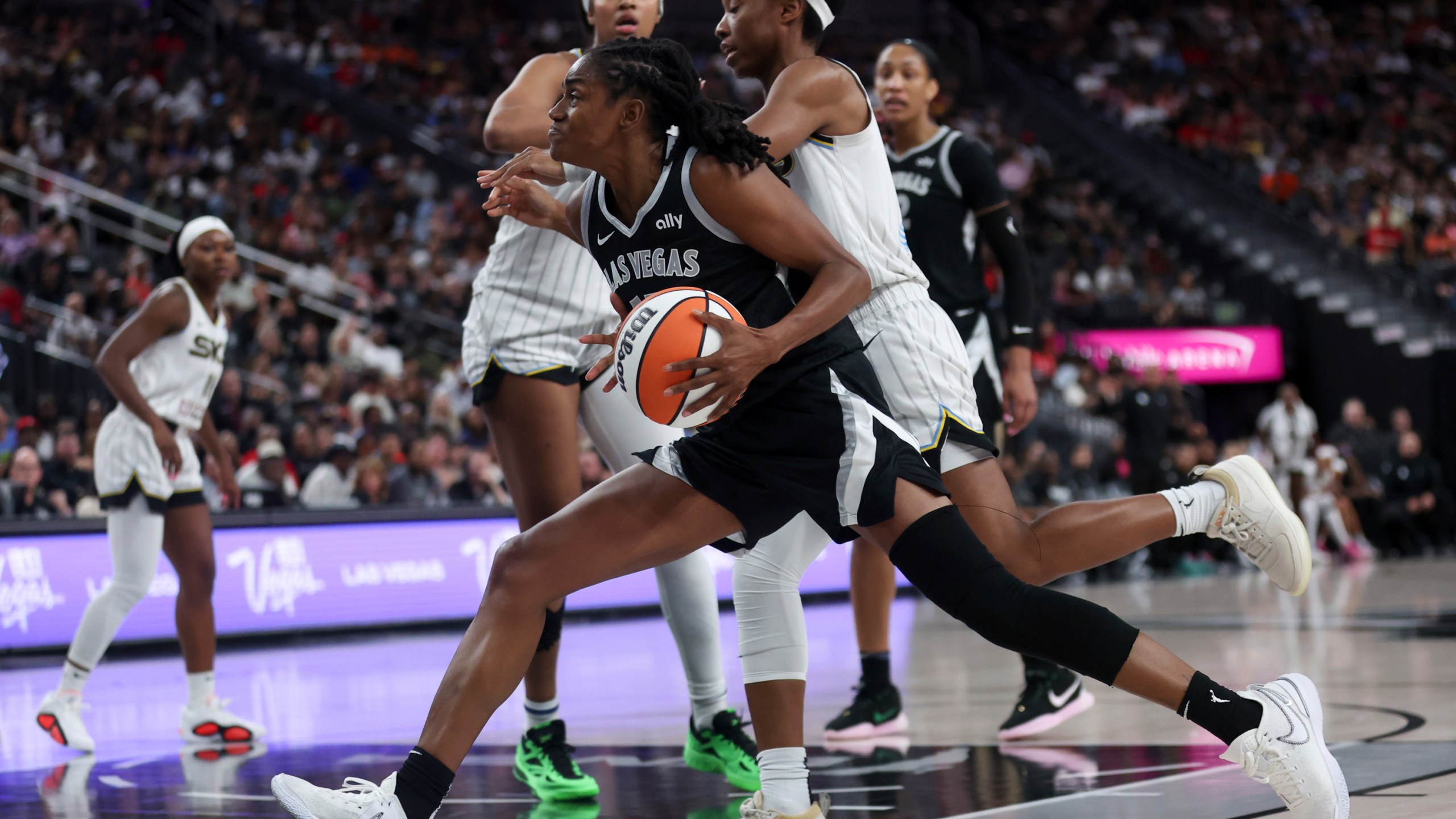 Las Vegas Aces guard Tiffany Hayes drives toward the hoop against Chicago Sky forward Angel Reese, back left, and guard Lindsay Allen, right, during the second half of an WNBA basketball game, Tuesday, Sept. 3, 2024, in Las Vegas. L (Ellen Schmidt/Las Vegas Sun via AP)