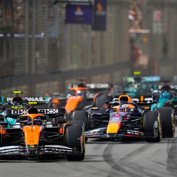 McLaren driver Lando Norris, left, of Britain leads Red Bull driver Max Verstappen of the Netherlands into turn one at the start of the Singapore Formula One Grand Prix at the Marina Bay Street Circuit, in Singapore, Sunday, Sept. 22, 2024. (AP Photo/Vincent Thian)