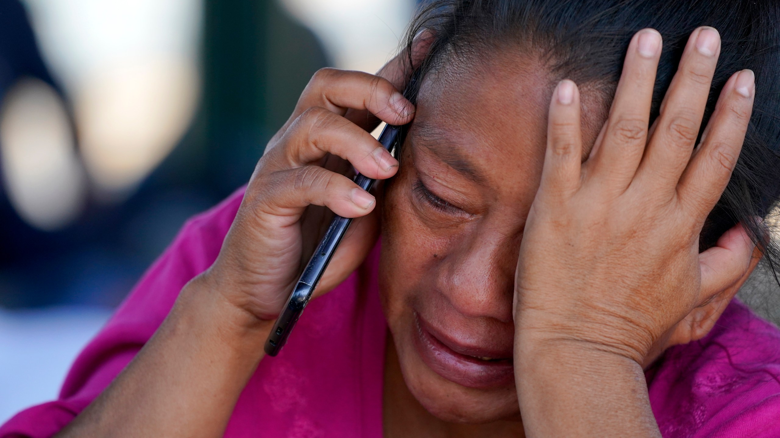 FILE - A migrant woman cries as she talks on a cellphone at a park after she and a large group of deportees from the U.S. were pushed by Mexican authorities off an area they had been staying after their expulsion, Saturday, March 20, 2021, in Reynosa, Mexico. (AP Photo/Julio Cortez)