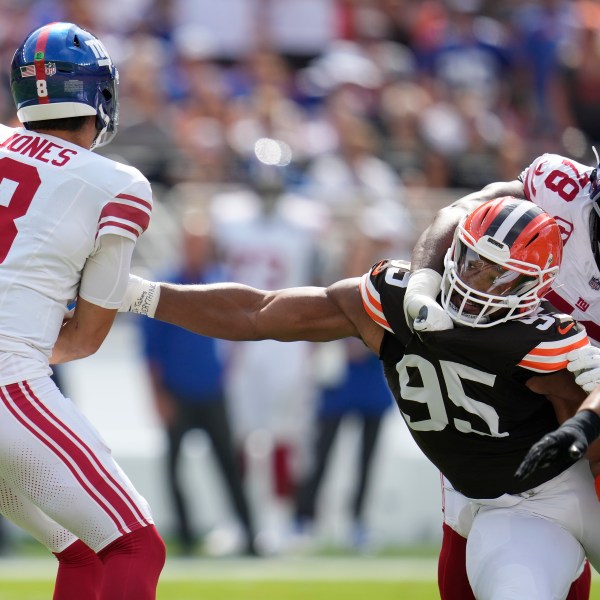 Cleveland Browns defensive end Myles Garrett (95) reaches for New York Giants quarterback Daniel Jones (8) while being blocked by offensive tackle Andrew Thomas (78) during the first half of an NFL football game, Sunday, Sept. 22, 2024 in Cleveland. (AP Photo/Sue Ogrocki)