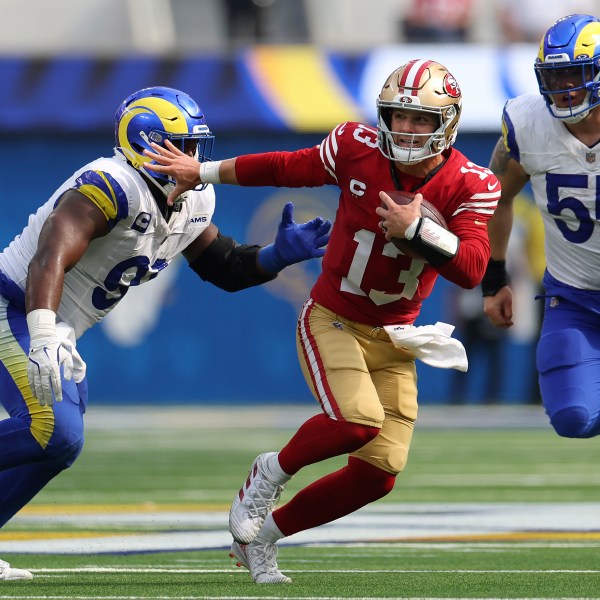 San Francisco 49ers quarterback Brock Purdy (13) runs against Los Angeles Rams defensive tackle Kobie Turner, left, and defensive tackle Braden Fiske (55) during the second half of an NFL football game, Sunday, Sept. 22, 2024, in Inglewood, Calif. (AP Photo/Ryan Sun)