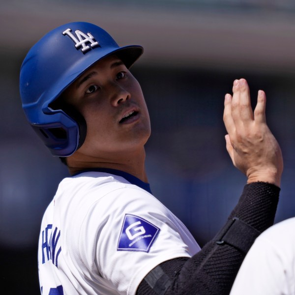 Los Angeles Dodgers' Shohei Ohtani acknowledges the first base umpire after hitting a single during the first inning of a baseball game against the Colorado Rockies, Sunday, Sept. 22, 2024, in Los Angeles. (AP Photo/Mark J. Terrill)