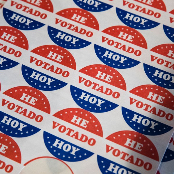 FILE - Spanish language voting stickers which read "He Votado Hoy" ("I Voted Today") are offered at a polling place in Philadelphia, May 21, 2019. (AP Photo/Matt Rourke, File)