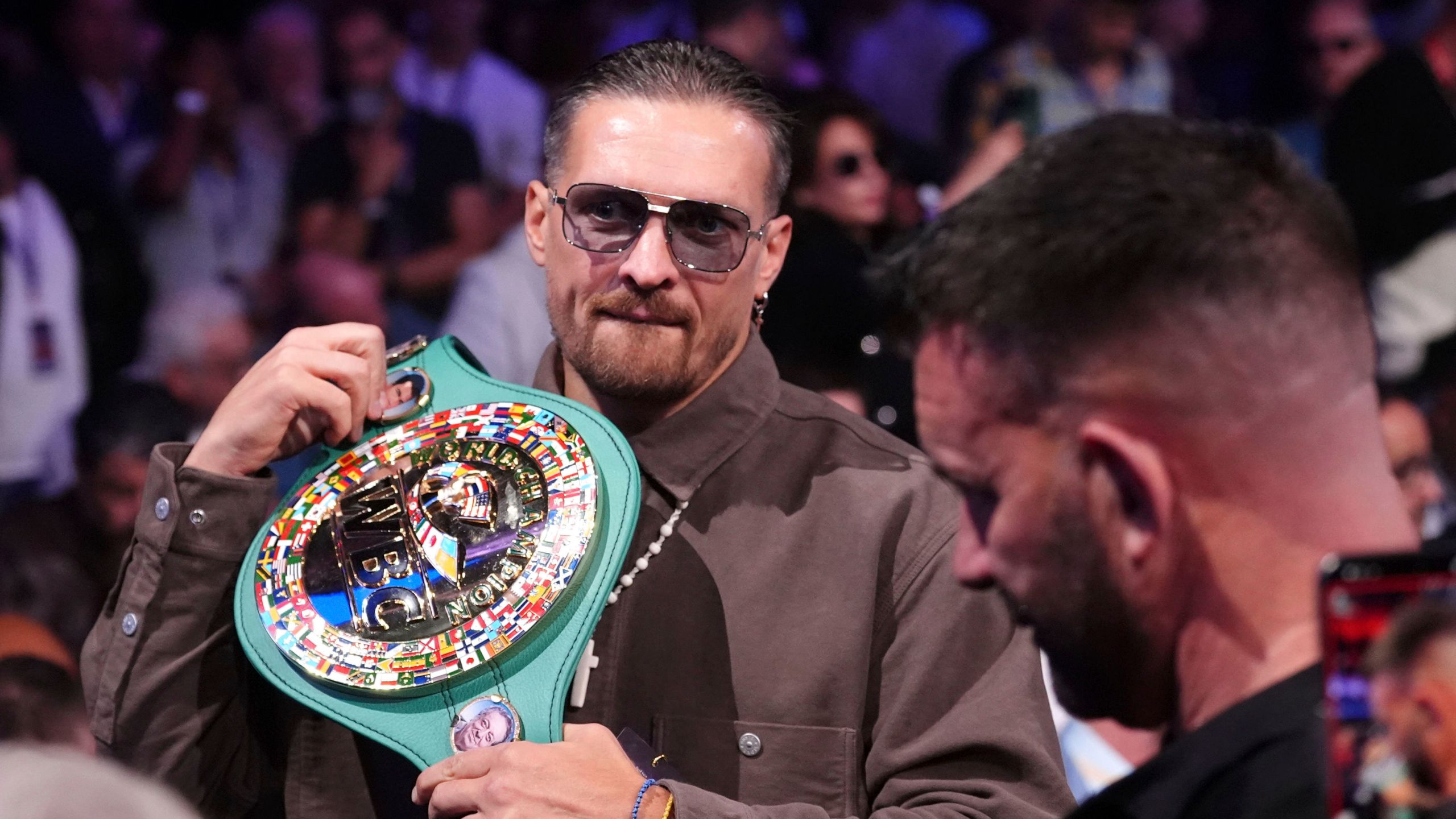 Ukrainian boxer Oleksandr Usyk in the stands with his belt at Wembley Stadium, in London, Saturday, Sept. 21, 2024. (Bradley Collyer/PA via AP)