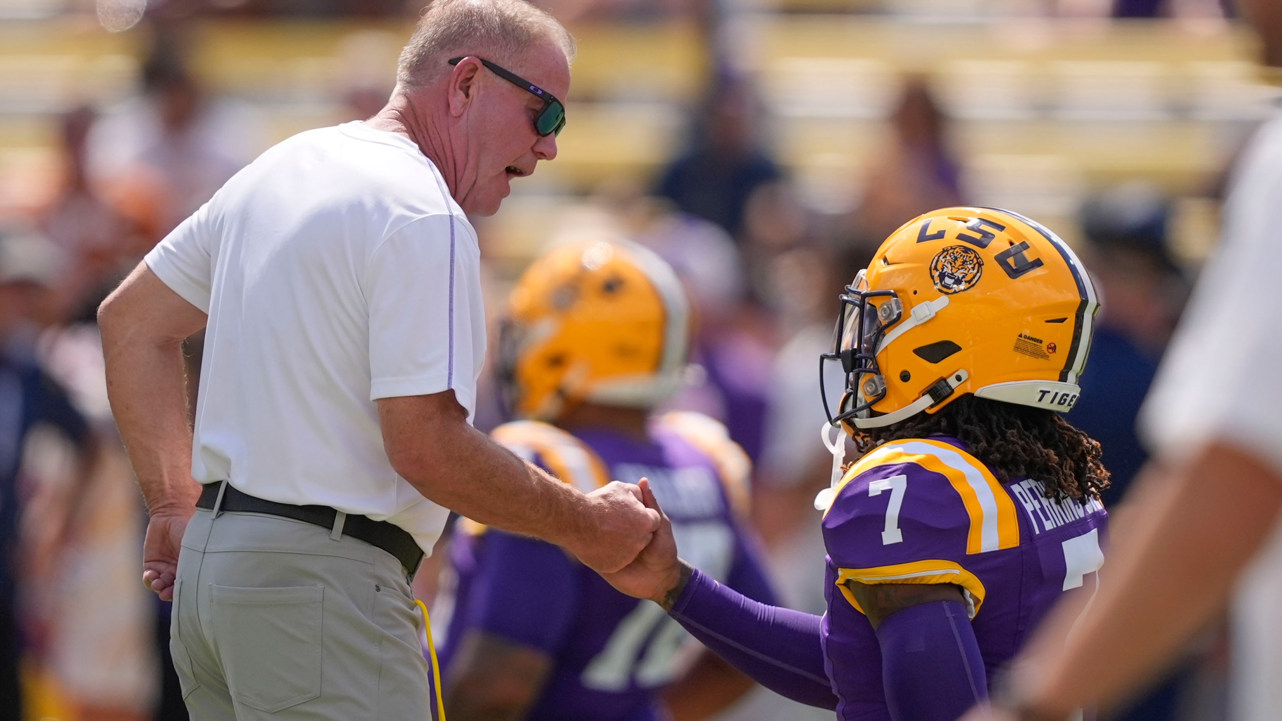 LSU head coach Brian Kelly greets linebacker Harold Perkins Jr. (7) before an NCAA college football game against UCLA in Baton Rouge, La., Saturday, Sept. 21, 2024. (AP Photo/Gerald Herbert)