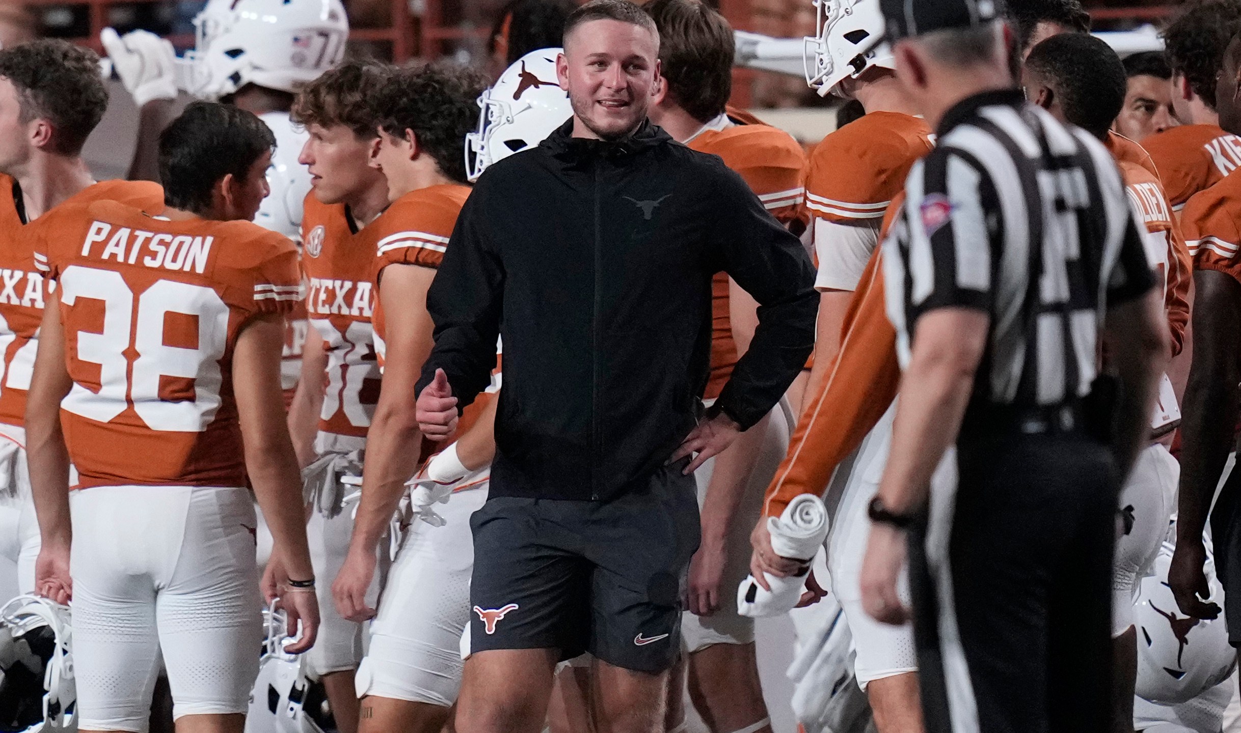 Texas quarterback Quinn Ewers, center, stands on the sidelines in street cloths after he was injured during the second half of an NCAA college football game against UTSA in Austin, Texas, Saturday, Sept. 14, 2024. (AP Photo/Eric Gay)