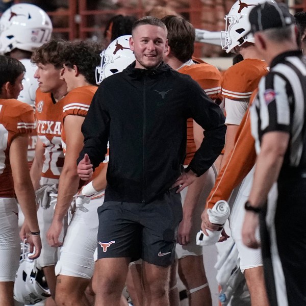 Texas quarterback Quinn Ewers, center, stands on the sidelines in street cloths after he was injured during the second half of an NCAA college football game against UTSA in Austin, Texas, Saturday, Sept. 14, 2024. (AP Photo/Eric Gay)