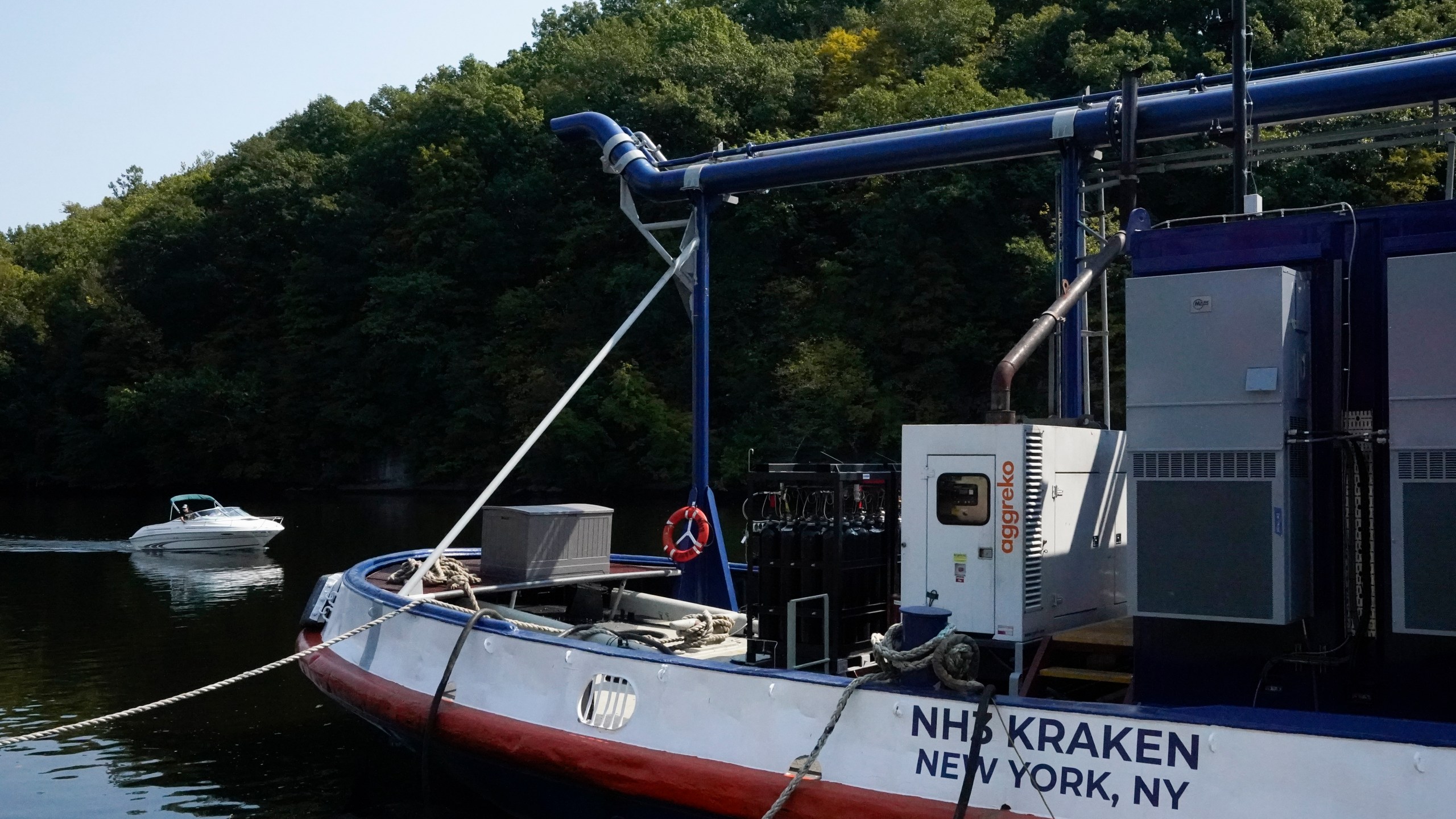 A boat, left, passes by the NH3 Kraken, a tugboat powered by ammonia, Friday, Sept. 13, 2024, in Kingston, N.Y. (AP Photo/Alyssa Goodman)