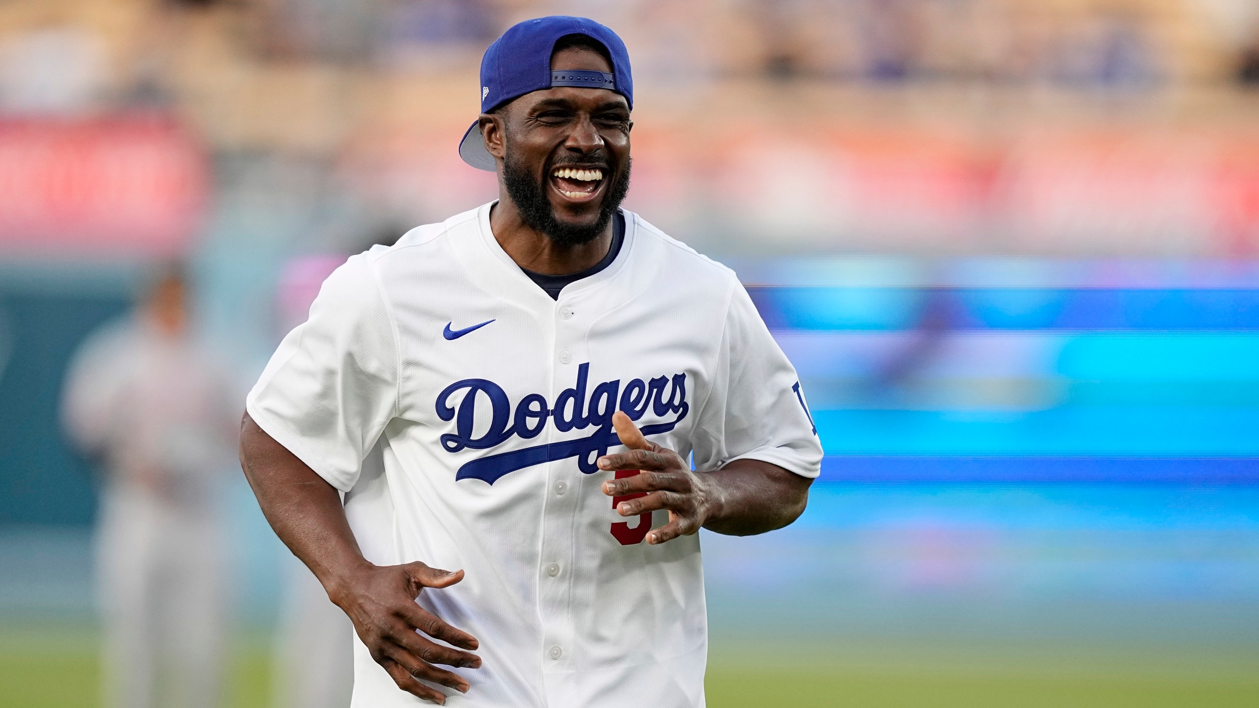 FILE - Former NFL and University of Southern California running back Reggie Bush, left, jokes with laughs after throwing out the ceremonial first pitch prior to a baseball game between the Los Angeles Dodgers and the Cincinnati Reds Friday, May 17, 2024, in Los Angeles. (AP Photo/Mark J. Terrill, File)