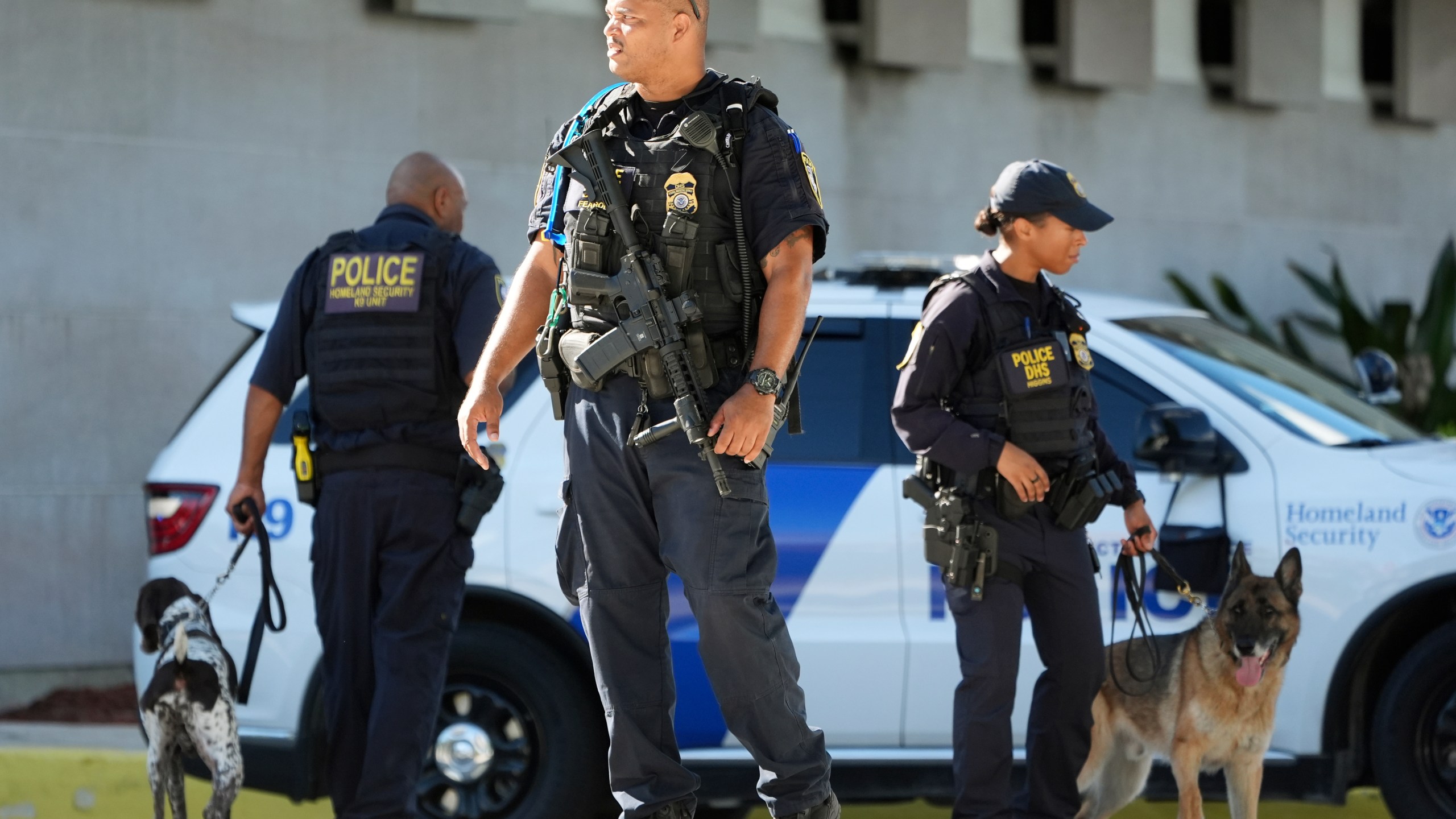 Department of Homeland Security officers patrol outside the Paul G. Rogers Federal Building and U.S. Courthouse, where Ryan Wesley Routh, 58, suspected in an apparent assassination attempt targeting former President Donald Trump, will be attending a hearing, Monday, Sept. 23, 2024, in West Palm Beach, Fla. (AP Photo/Wilfredo Lee)