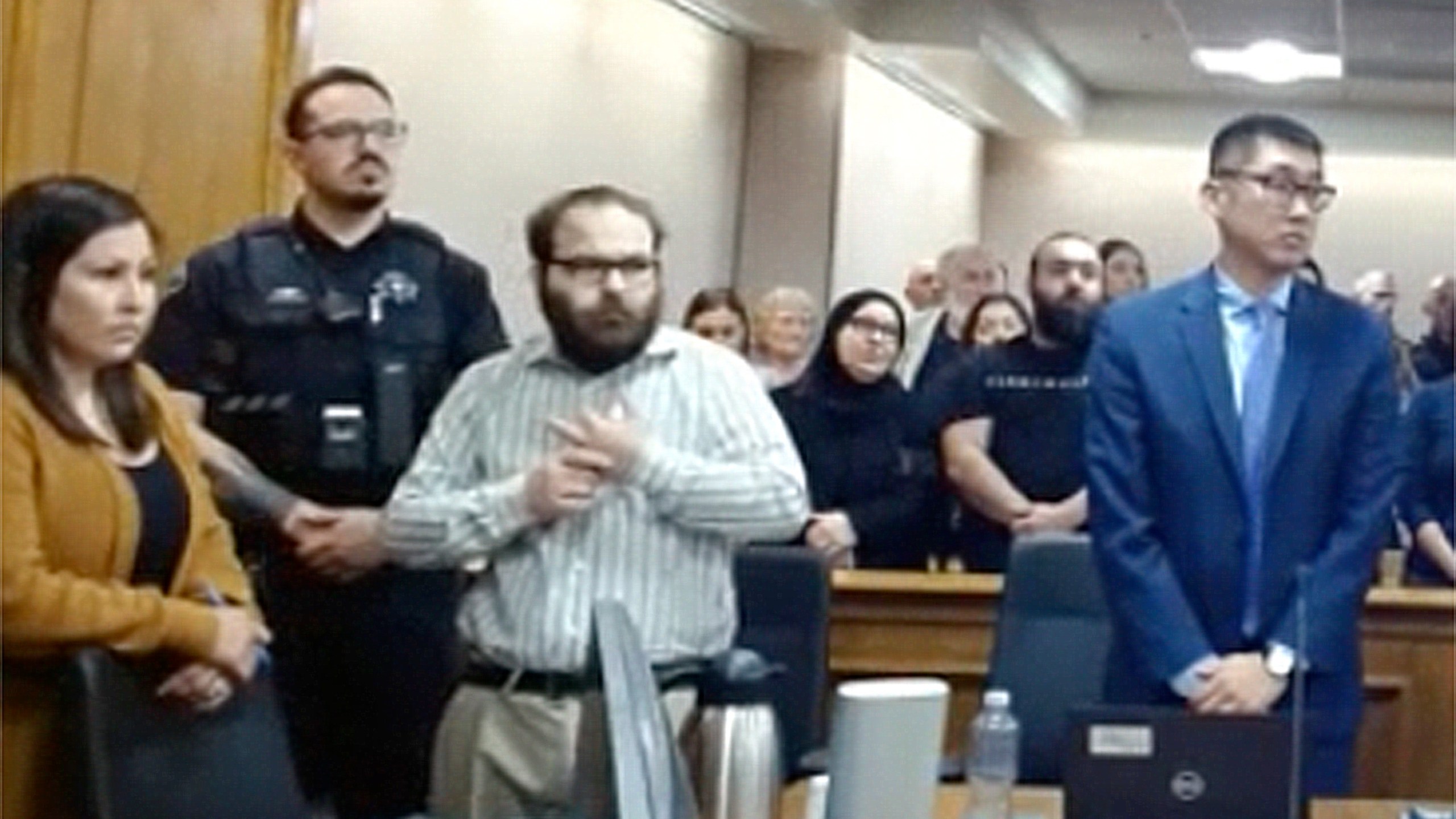 In this image taken from video provided by the Colorado Judicial Branch, Ahmad Alissa, third from left, stands for the verdict in his trial for the 2021 Colorado supermarket shootings, Monday, Sept 23, 2024, in Boulder, Colo. (Colorado Judicial Branch via AP)