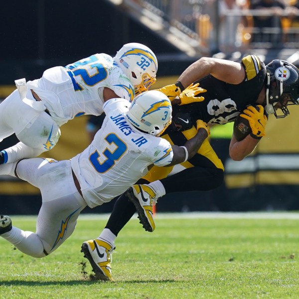 Pittsburgh Steelers tight end Pat Freiermuth, right, is tackled by Los Angeles Chargers safeties Alohi Gilman (32) and Derwin James Jr. during the second half of an NFL football game, Sunday, Sept. 22, 2024, in Pittsburgh. (AP Photo/Matt Freed)