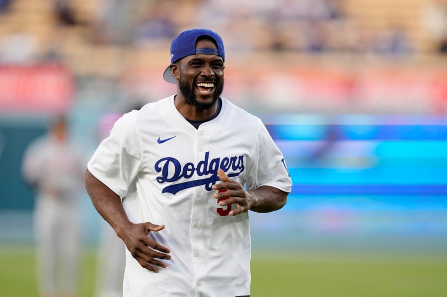 FILE - Former NFL and University of Southern California running back Reggie Bush, left, jokes with laughs after throwing out the ceremonial first pitch prior to a baseball game between the Los Angeles Dodgers and the Cincinnati Reds Friday, May 17, 2024, in Los Angeles. (AP Photo/Mark J. Terrill, File)