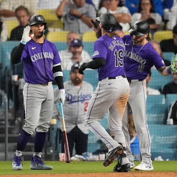 Colorado Rockies designated hitter Charlie Blackmon (19) celebrates with Jake Cave (11) and Ezequiel Tovar (14) after hitting a home run during the ninth inning of a baseball game against the Los Angeles Dodgers in Los Angeles, Saturday, Sept. 21, 2024. Cave also scored. (AP Photo/Ashley Landis)