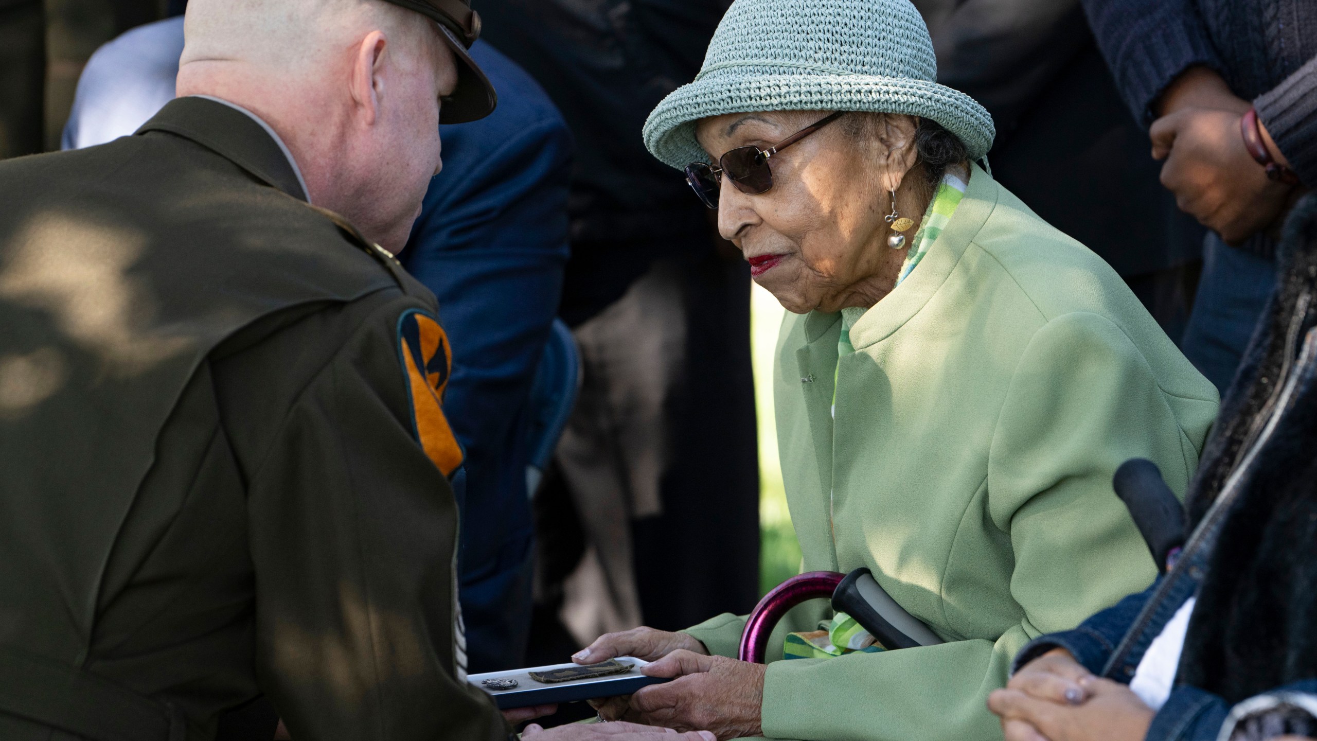 FILE - First Army's Command Sgt. Maj. Chris Prosser, left, presents Joann Woodson with her husband's Combat Medic Badge during a posthumous medal ceremony at Arlington National Cemetery Oct. 11, 2023 in Arlington, Va. (AP Photo/Kevin Wolf, File)