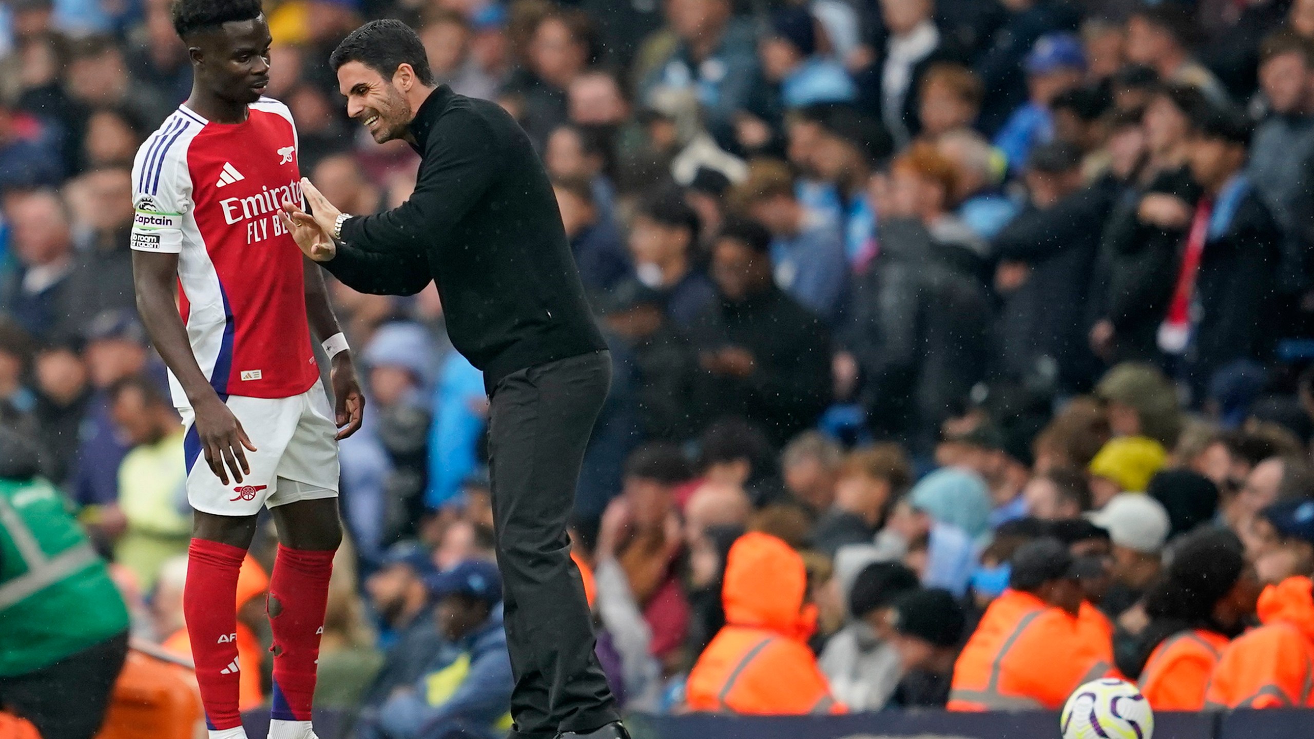 Arsenal's manager Mikel Arteta speaks to Arsenal's Bukayo Saka during the English Premier League soccer match between Manchester City and Arsenal at the Etihad stadium in Manchester, England, Sunday, Sept. 22, 2024. (AP Photo/Dave Thompson)