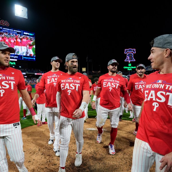 Philadelphia Phillies' Alec Bohm, from left, Jeff Hoffman, Bryce Harper, Kyle Schwarber, Garrett Stubbs and J.T. Realmuto celebrate after winning a baseball game against the Chicago Cubs to clinch the NL East title, Monday, Sept. 23, 2024, in Philadelphia. (AP Photo/Matt Slocum)