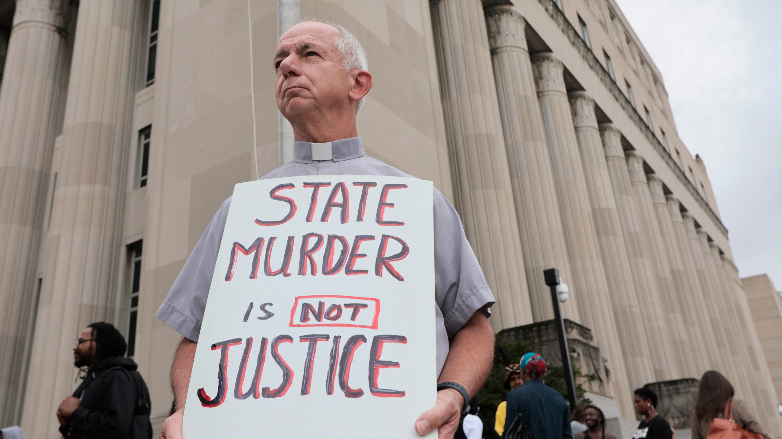 Deacon Dave Billips, with the Office of Peace and Justice with the St. Louis Archdiocese, holds a sign as he stands with protesters holding space to halt the execution of Marcellus Williams on Tuesday, Sept. 24, 2024, outside the Carnahan Courthouse in St. Louis. (Laurie Skrivan/St. Louis Post-Dispatch via AP)