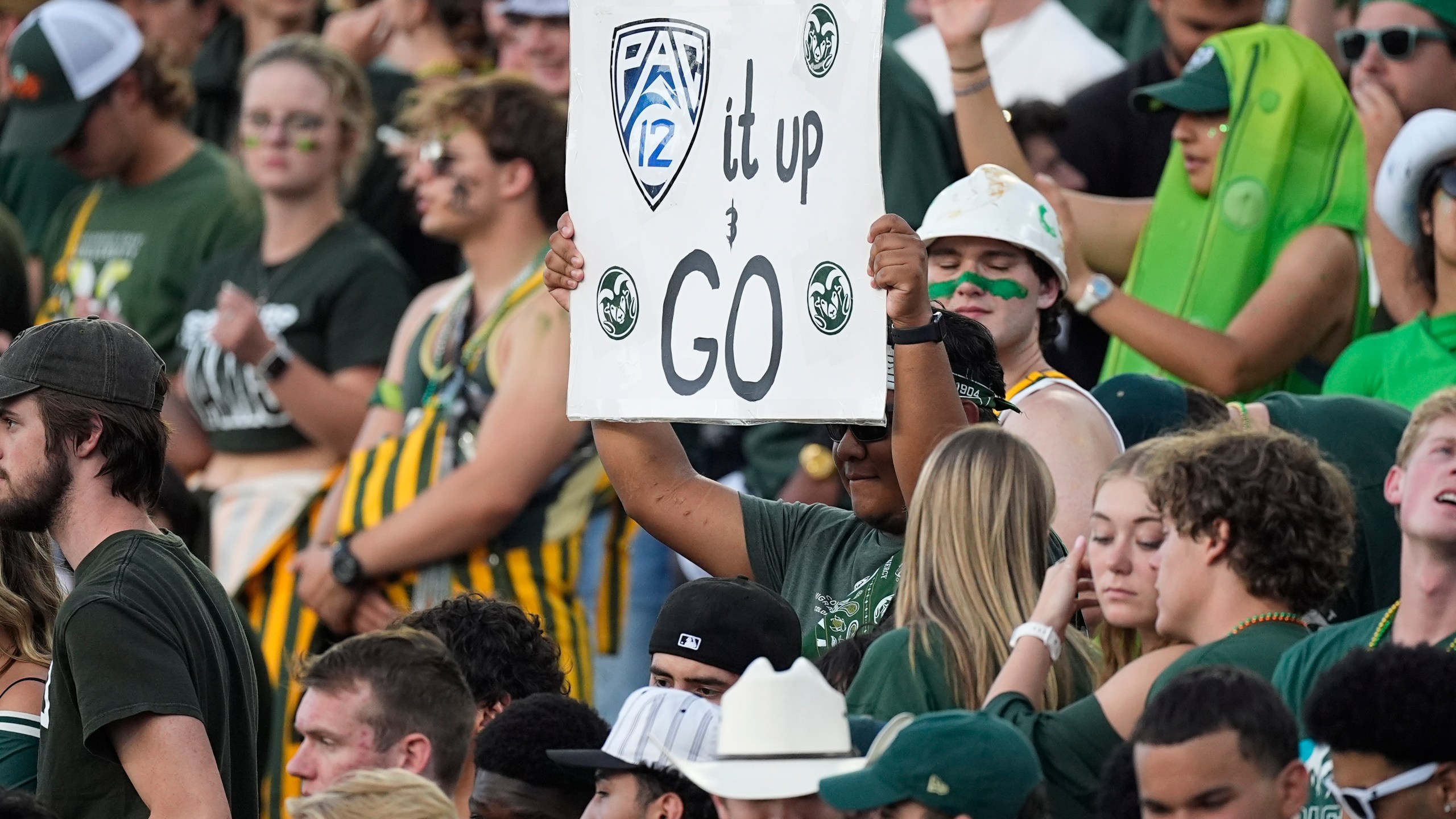 A Colorado State fan holds up a sign to mark the school's move to the Pac-12 Conference from the Mountain West during the first half of an NCAA college football game against Colorado, Saturday, Sept. 14, 2024, in Fort Collins, Colo. (AP Photo/David Zalubowski)