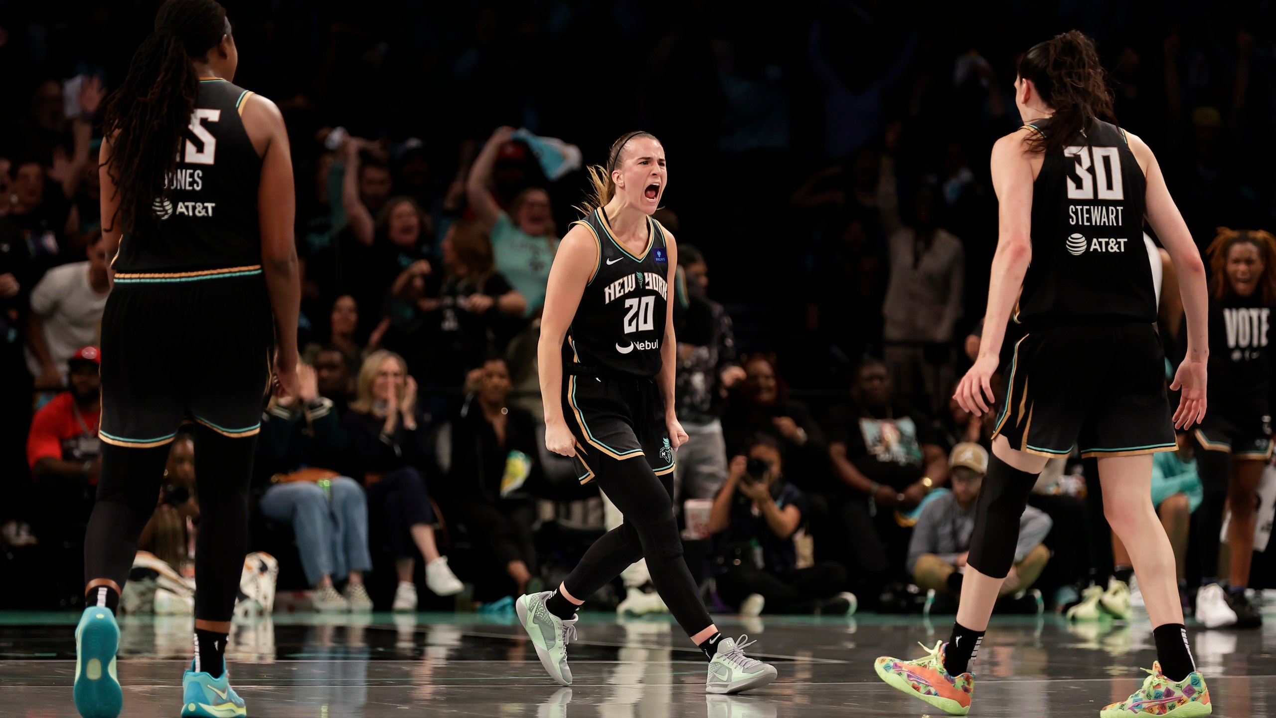 New York Liberty guard Sabrina Ionescu (20) reacts with Breanna Stewart (30) during the first half of a first-round WNBA basketball playoff game against the Atlanta Dream, Tuesday, Sept. 24, 2024, in New York. (AP Photo/Adam Hunger)