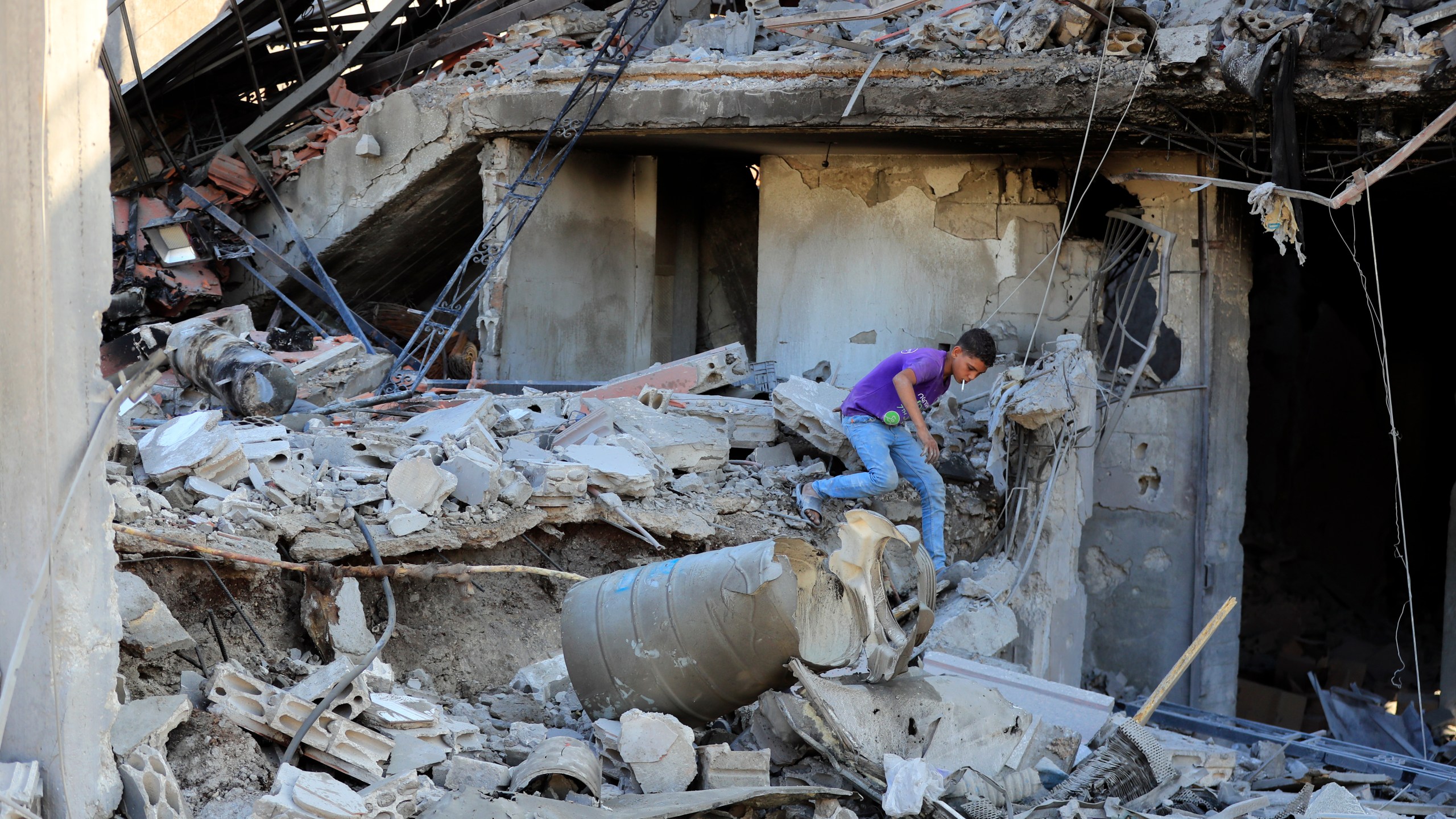 A boy checks the damage to a building hit in an Israeli airstrike in the southern village of Akbieh, Lebanon, Tuesday, Sept. 24, 2024. (AP Photo/Mohammed Zaatari)