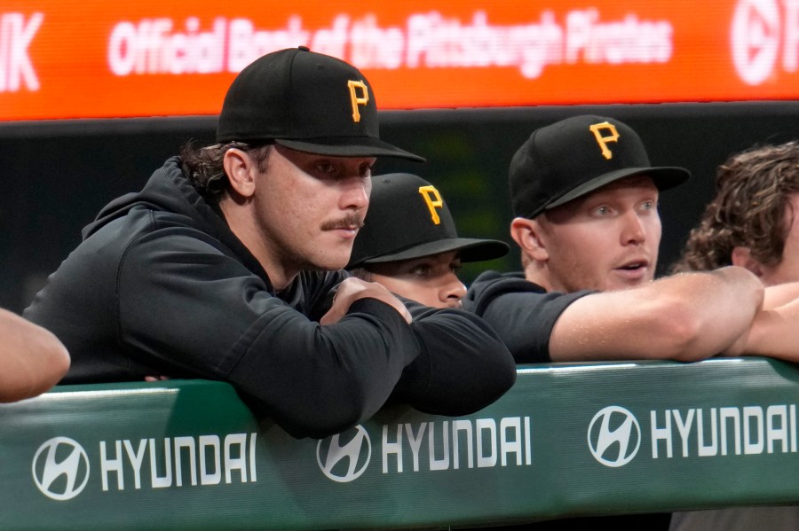 Pittsburgh Pirates pitcher Paul Skenes, left, with fellow pitchers Jared Jones, center, and Mitch Keller, right, watch from the dugout railing during the seventh inning of a baseball game against the Milwaukee Brewers in Pittsburgh, Tuesday, Sept. 24, 2024. (AP Photo/Gene J. Puskar)