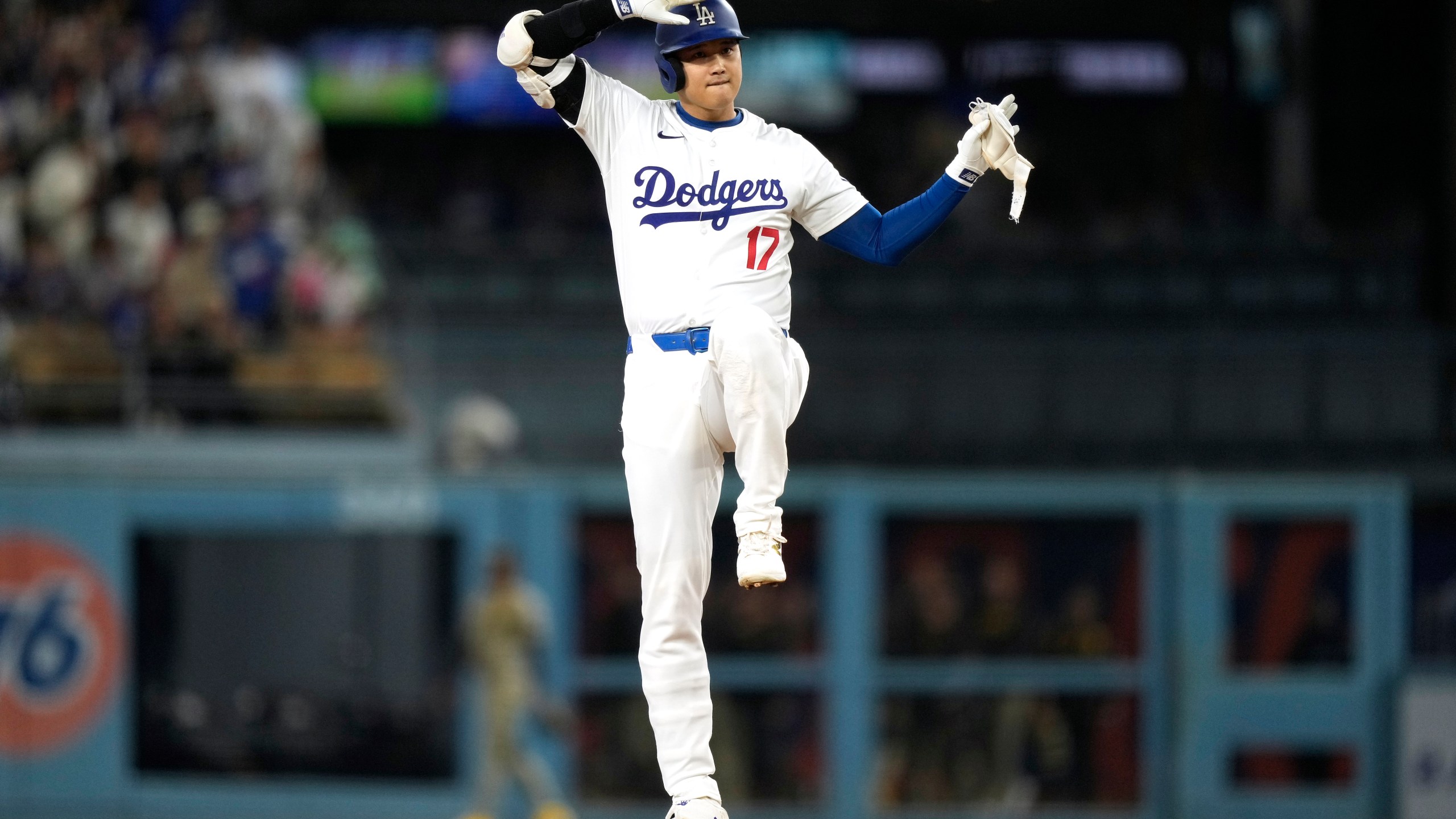 Los Angeles Dodgers' Shohei Ohtani gestures toward his dugout after hitting a double during the first inning of a baseball game against the San Diego Padres, Tuesday, Sept. 24, 2024, in Los Angeles. (AP Photo/Mark J. Terrill)