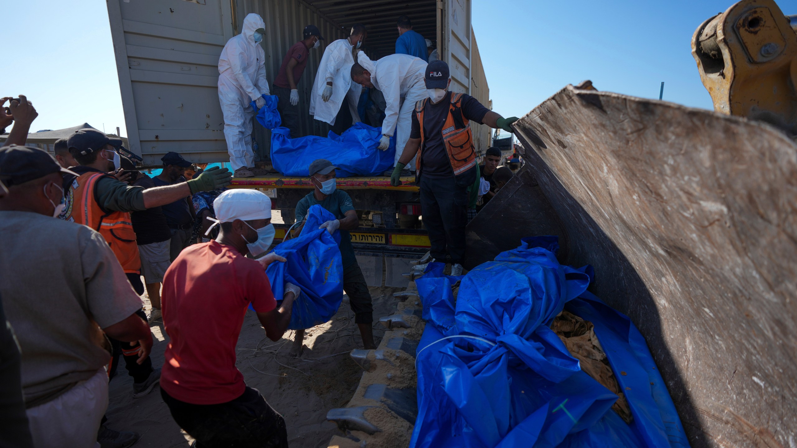 People bury the bodies of Palestinians taken by the Israeli military during operations in Gaza and returned this week, in Khan Younis, Gaza Strip, Thursday, Sept. 26, 2024. (AP Photo/Abdel Kareem Hana)