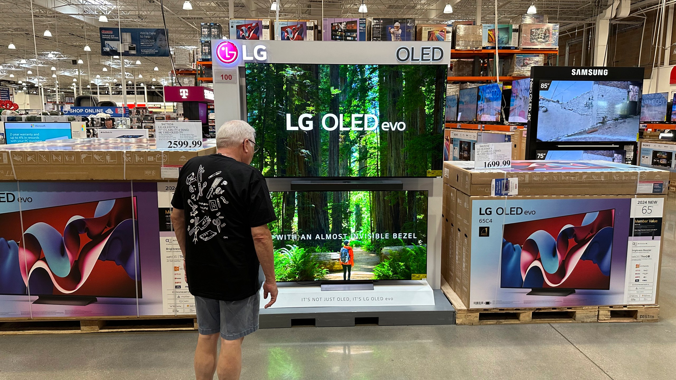 A shopper examines large-screen televisions on display in a Costco warehouse Thursday, Sept. 19, 2024, in Lone Tree, Colo. (AP Photo/David Zalubowski)