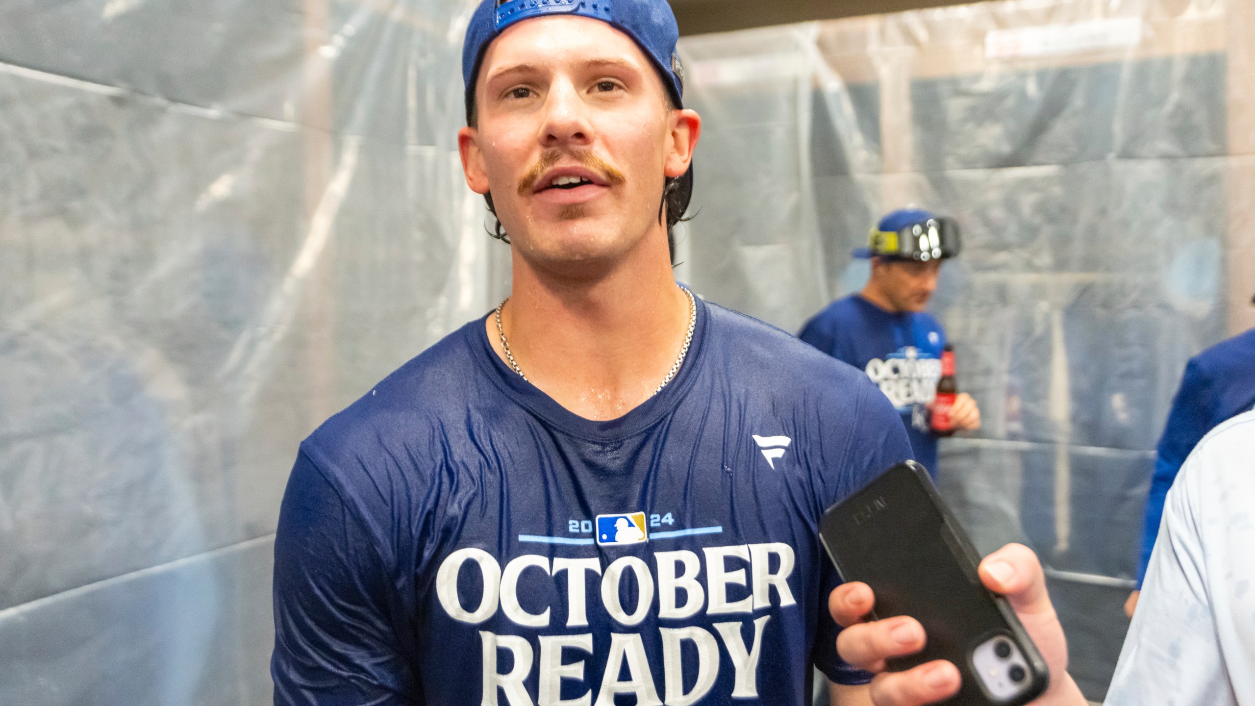 Kansas City Royals shortstop Bobby Witt Jr. speaks with a reporter during a celebration in the locker room after a baseball game against the Atlanta Braves, Friday, Sept. 27, 2024, in Atlanta. (AP Photo/Jason Allen)